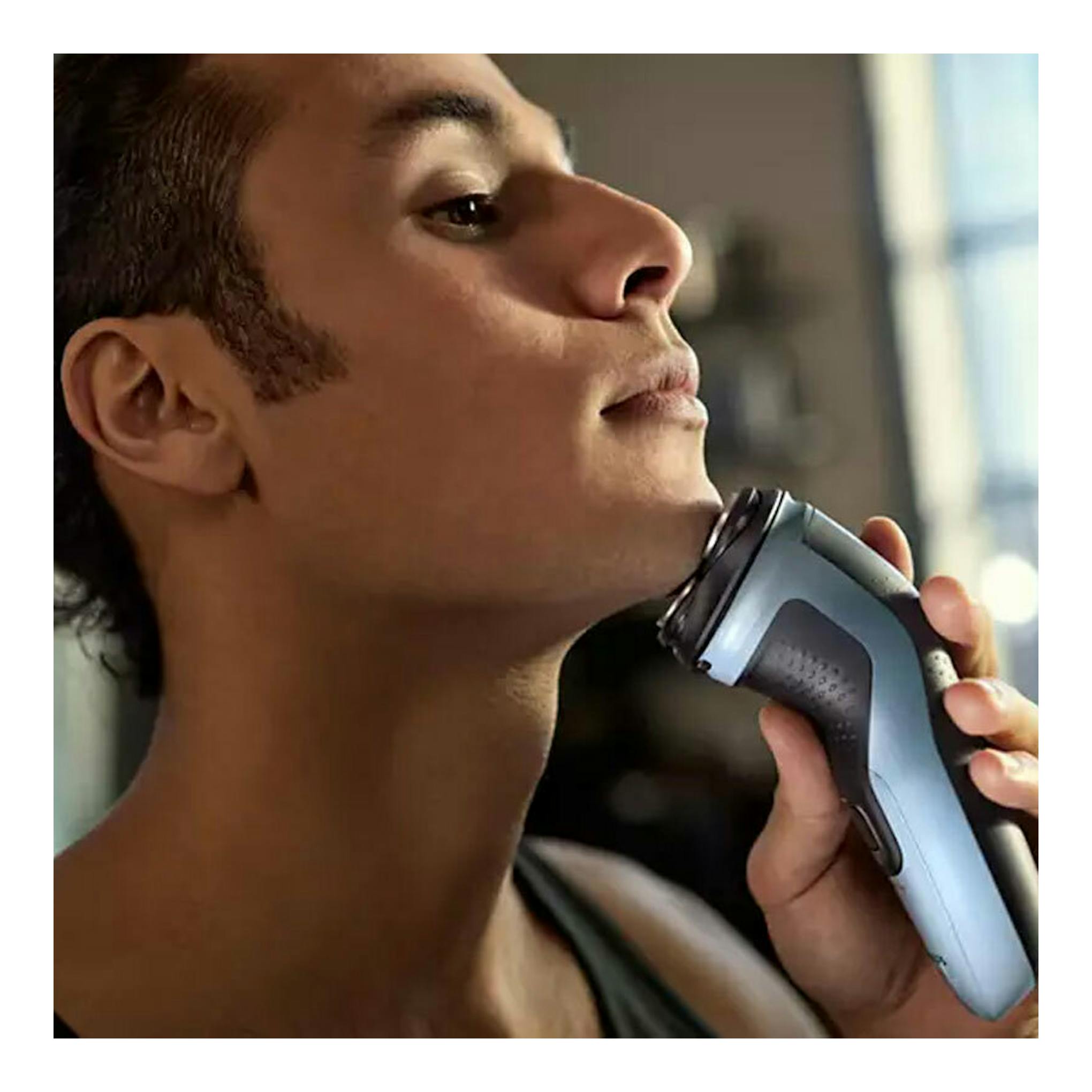 Philips X3003/00 afeitadora eléctrica azul, vista lateral, usada en el cuello de un hombre.