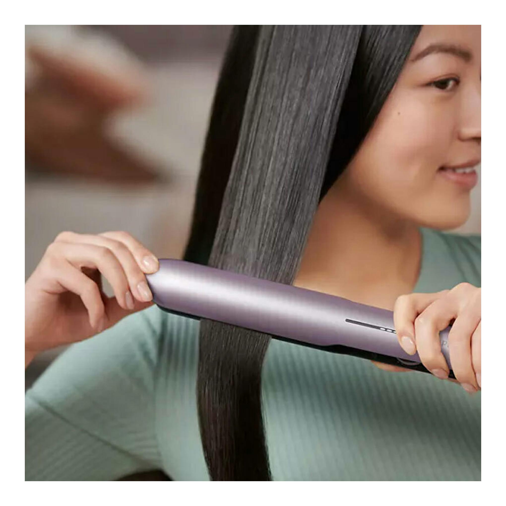 Plancha de pelo Philips BHS530/00 morada, vista lateral, alisando cabello negro.