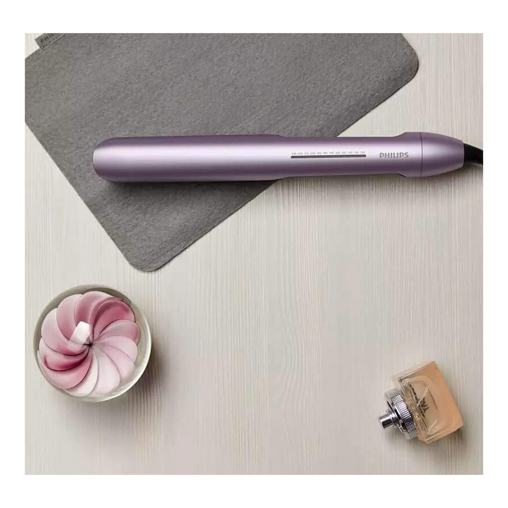Plancha de pelo Philips BHS530/00 lila, vista superior, sobre mesa clara con alfombrilla gris.