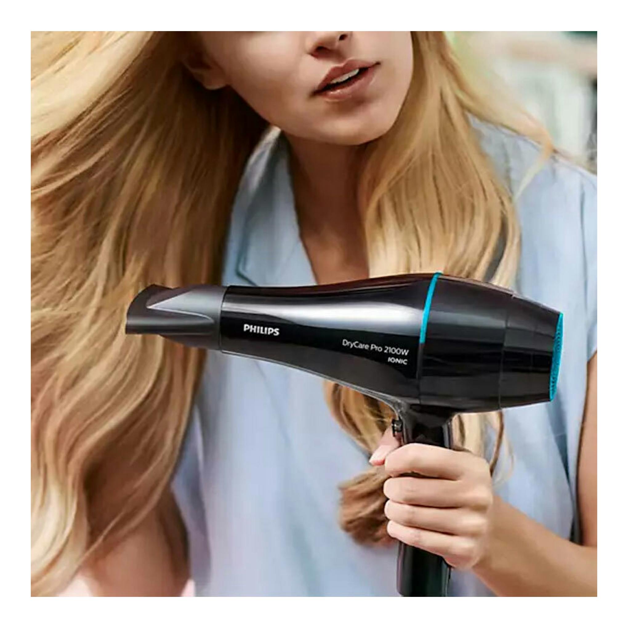 Secador Philips DryCare Pro 2100W IONIC negro, vista lateral, en uso frente a mujer rubia.