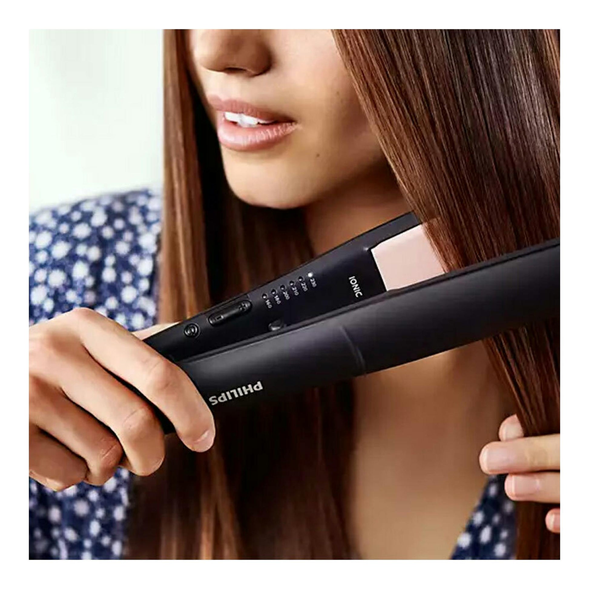 Plancha de pelo Philips BHS378/00 negra, vista frontal parcial, sujetada junto al cabello de una mujer.