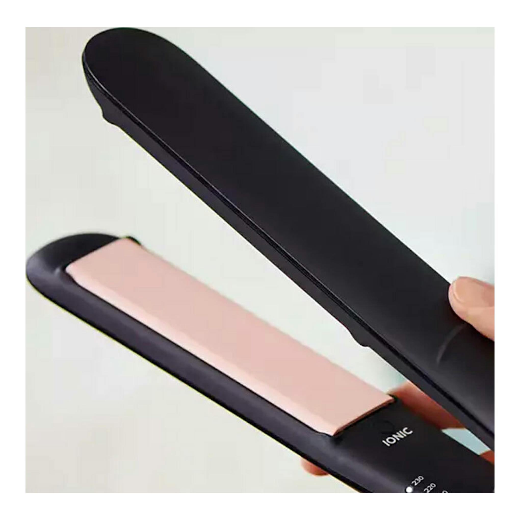 Plancha de pelo Philips BHS378/00 negra y rosa, en vista cercana, abierta y sostenida con la mano.