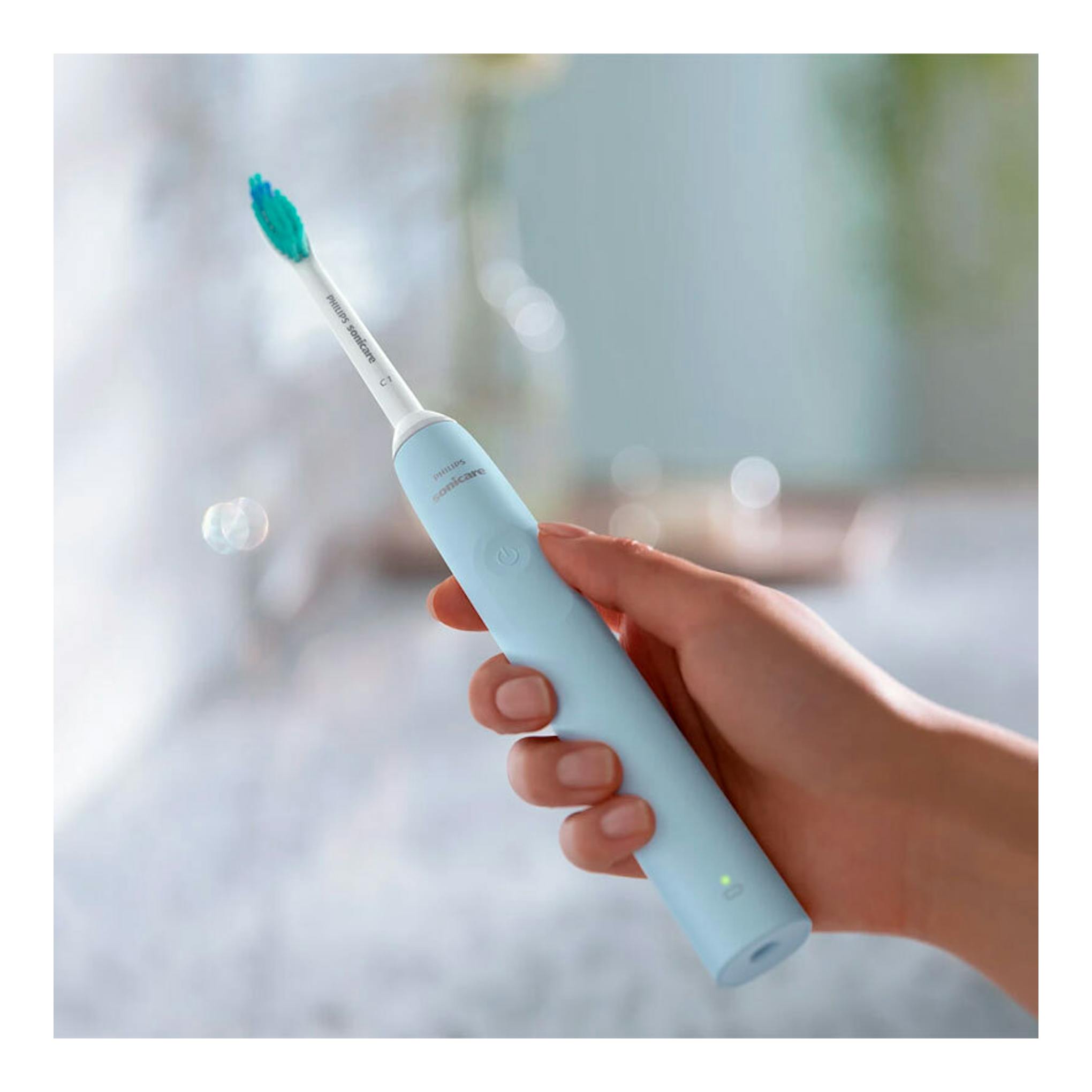 Cepillo dental eléctrico Philips Sonicare HX3651/12 azul claro, sujetado con una mano, vista frontal.