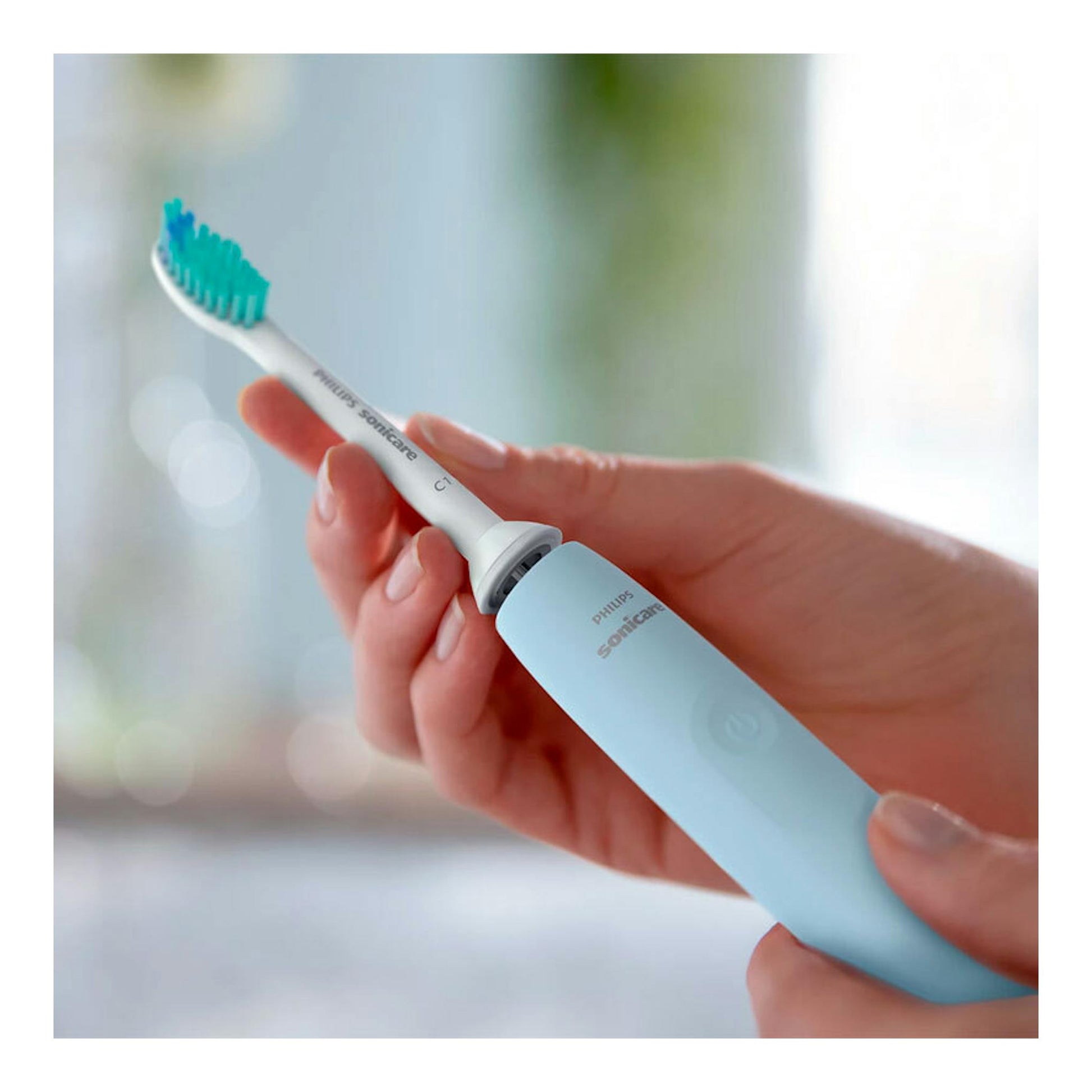 Cepillo dental eléctrico Philips Sonicare HX3651/12 azul claro, en primer plano, sostenido con la mano.