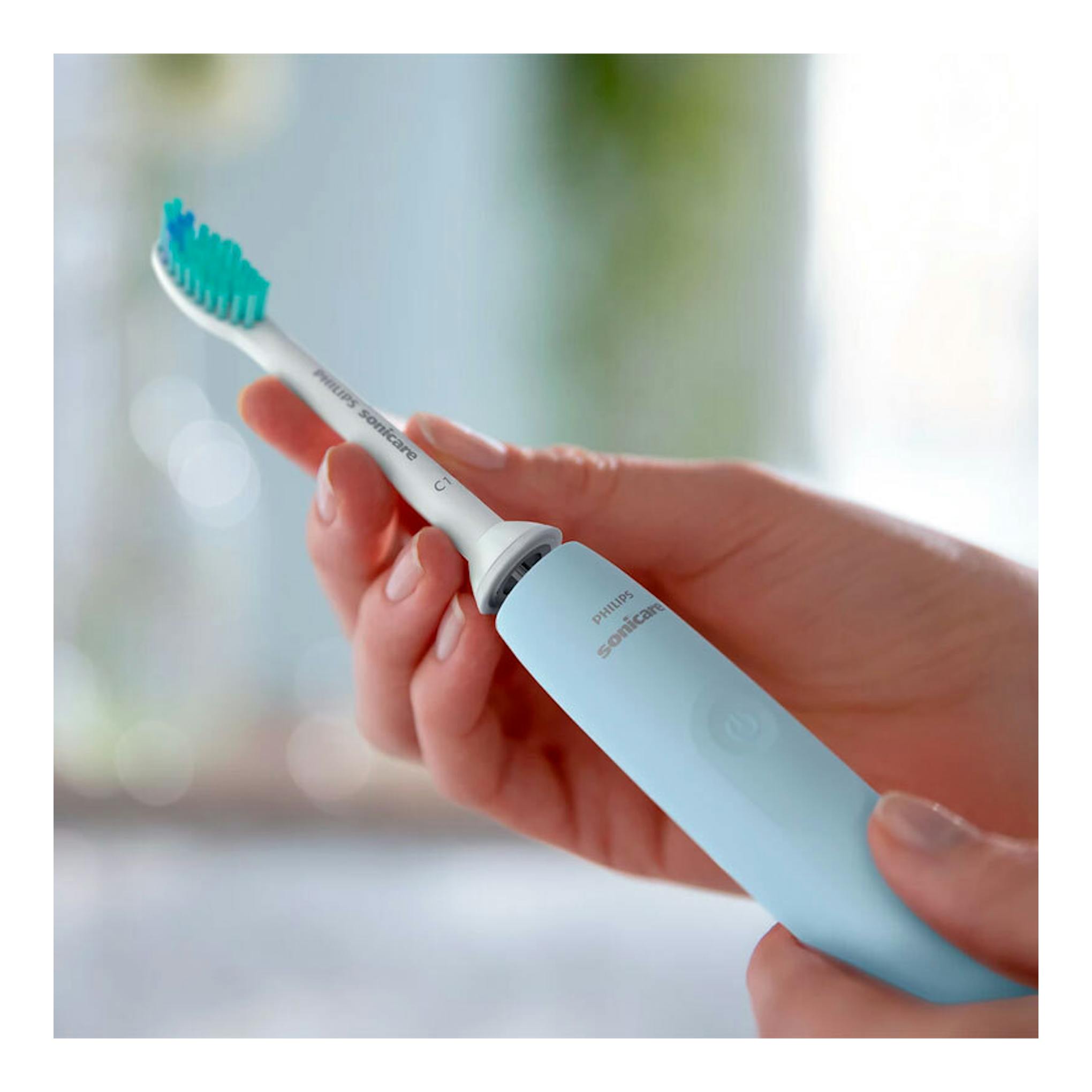 Cepillo dental eléctrico Philips Sonicare HX3651/12 azul claro, en primer plano, sostenido con la mano.