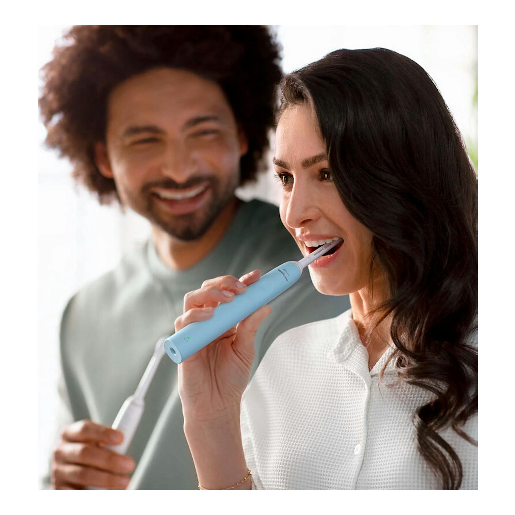 Mujer cepillándose con cepillo dental eléctrico Philips HX3651/12 azul, vista frontal.