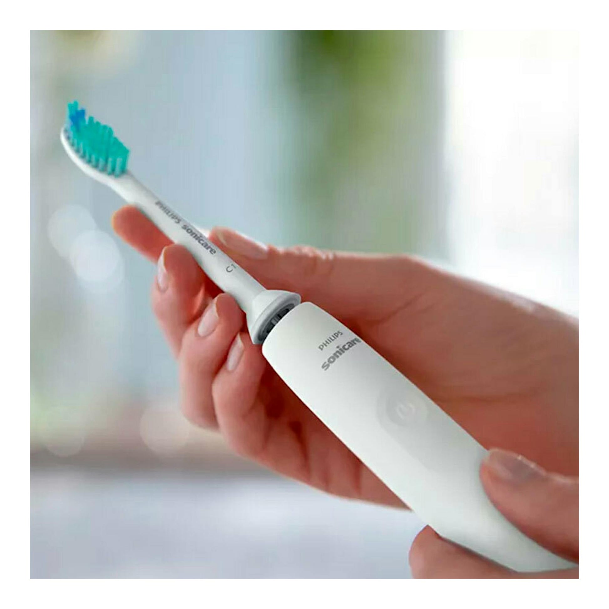 Cepillo dental eléctrico Philips Sonicare HX3651/13 blanco con cerdas azules, en primer plano sostenido con la mano.