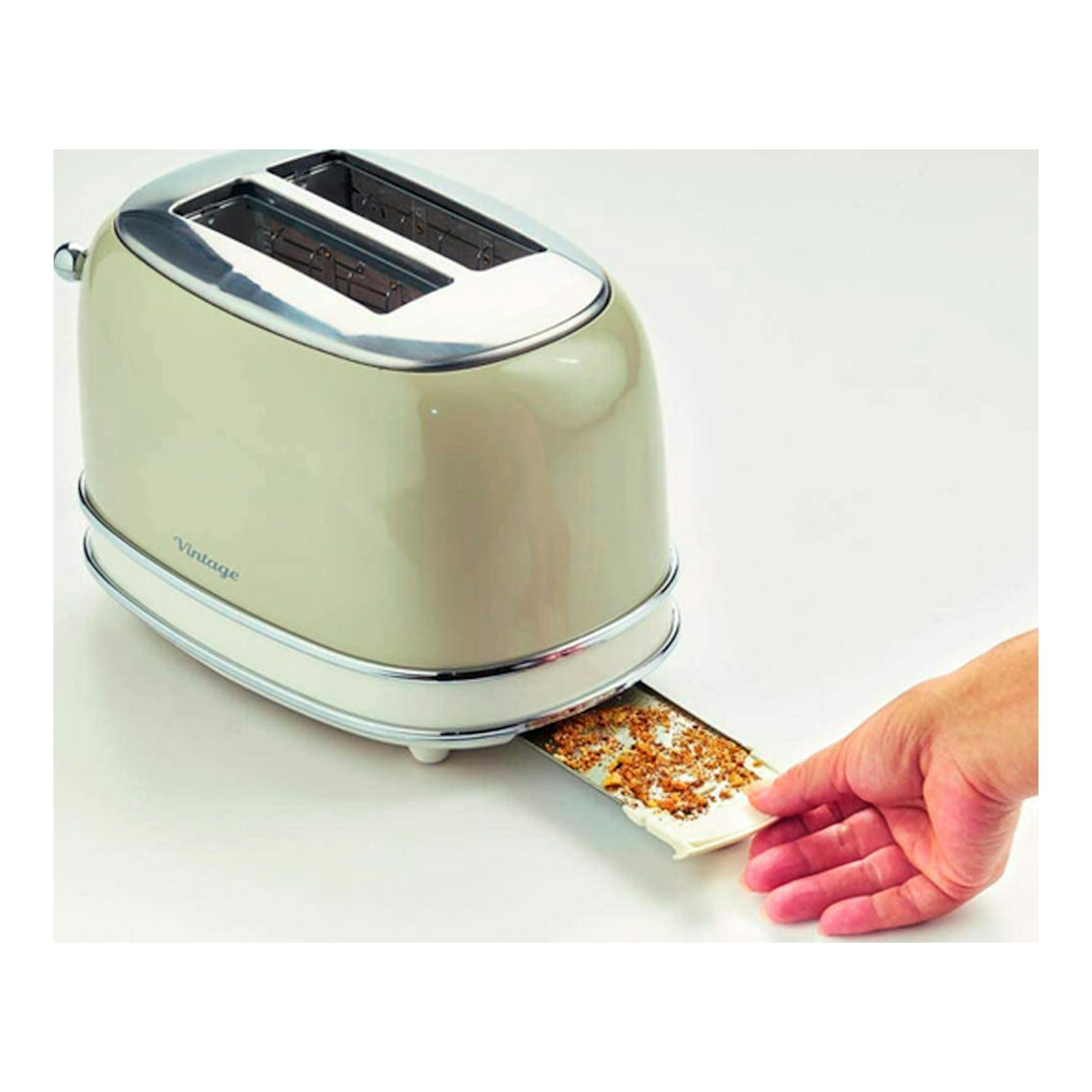 Tostador Ariete Vintage 155/13 beige, vista lateral, con dos ranuras y una mano sacando la bandeja de migas.