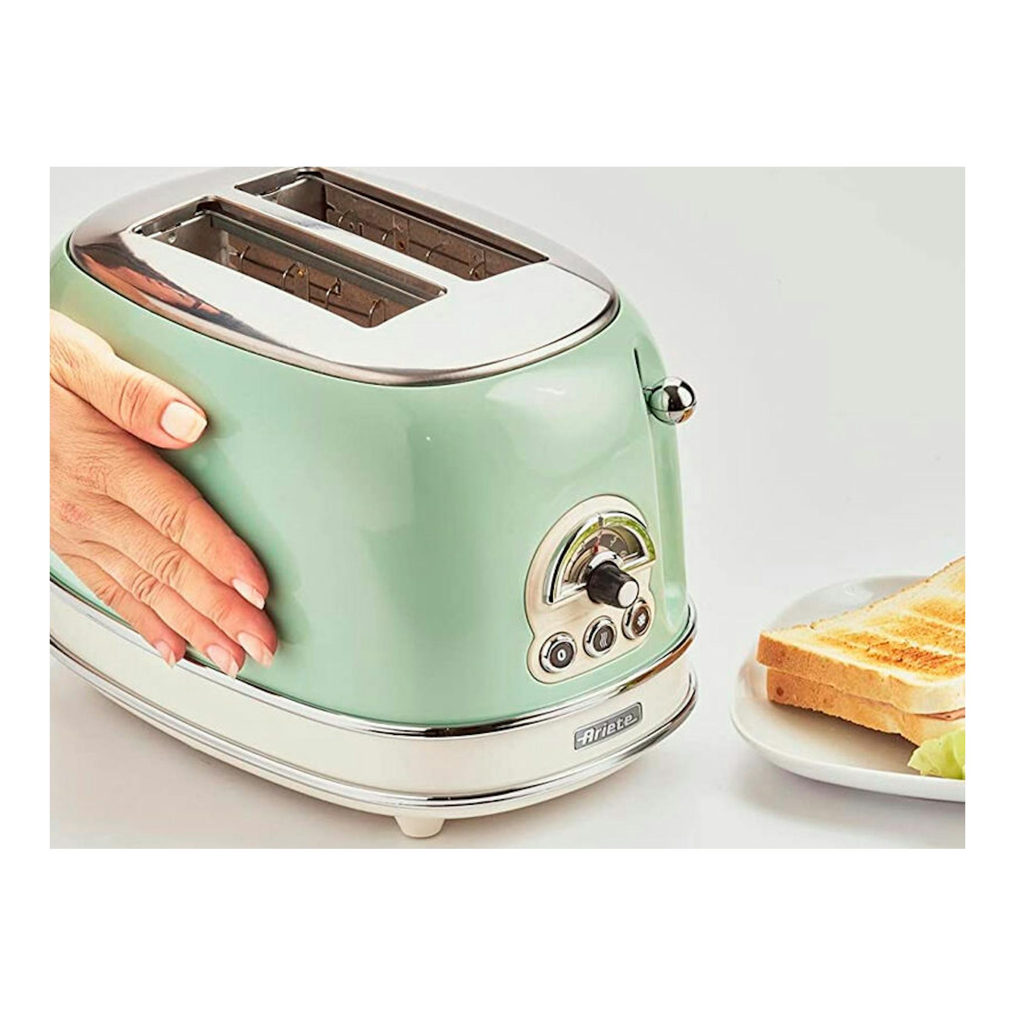 Tostador Ariete Vintage 155/14 verde menta, vista lateral, con 2 ranuras y mano sujetándolo.