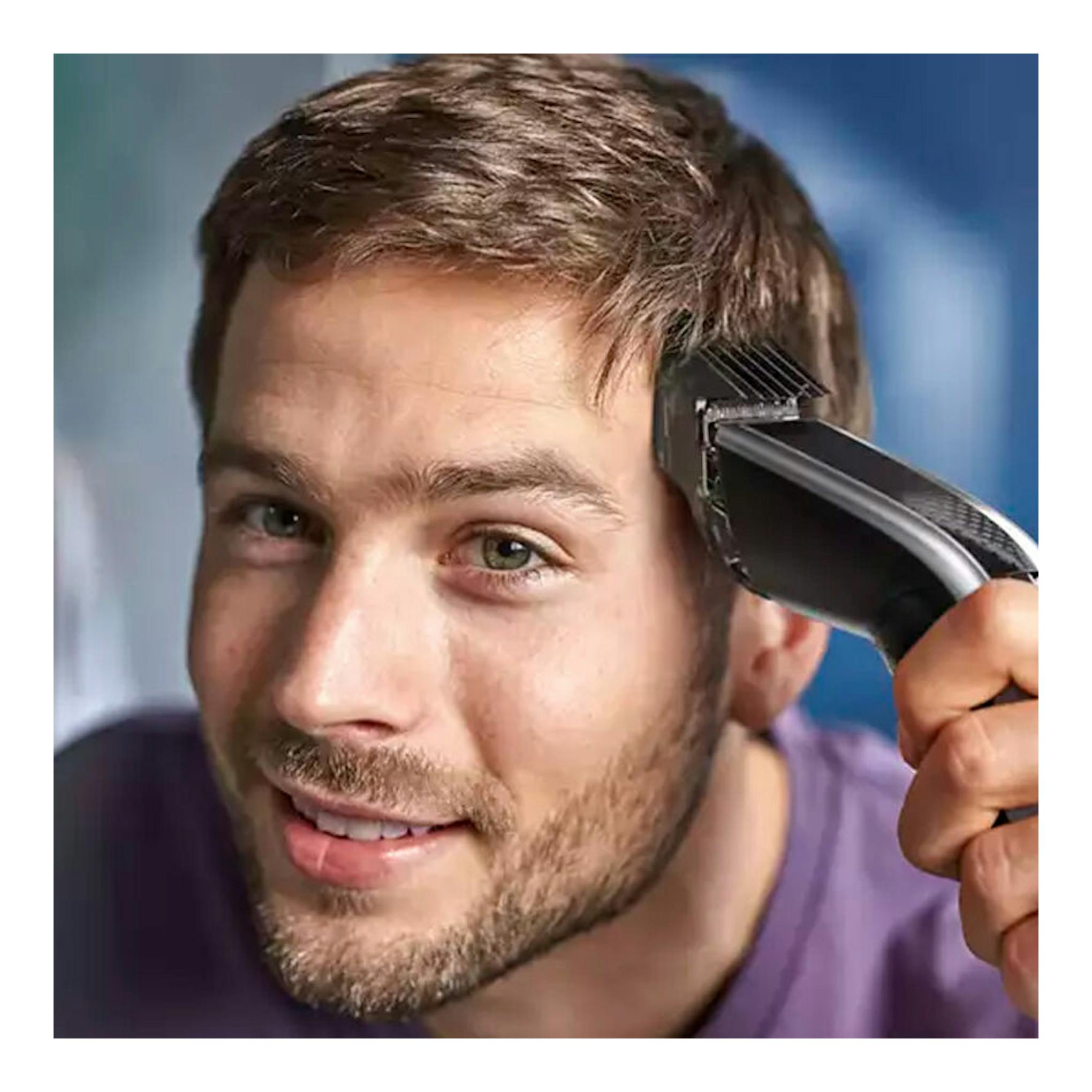 Primer plano de un hombre usando un cortapelo Philips HC5630/15 negro en el lateral de la cabeza.