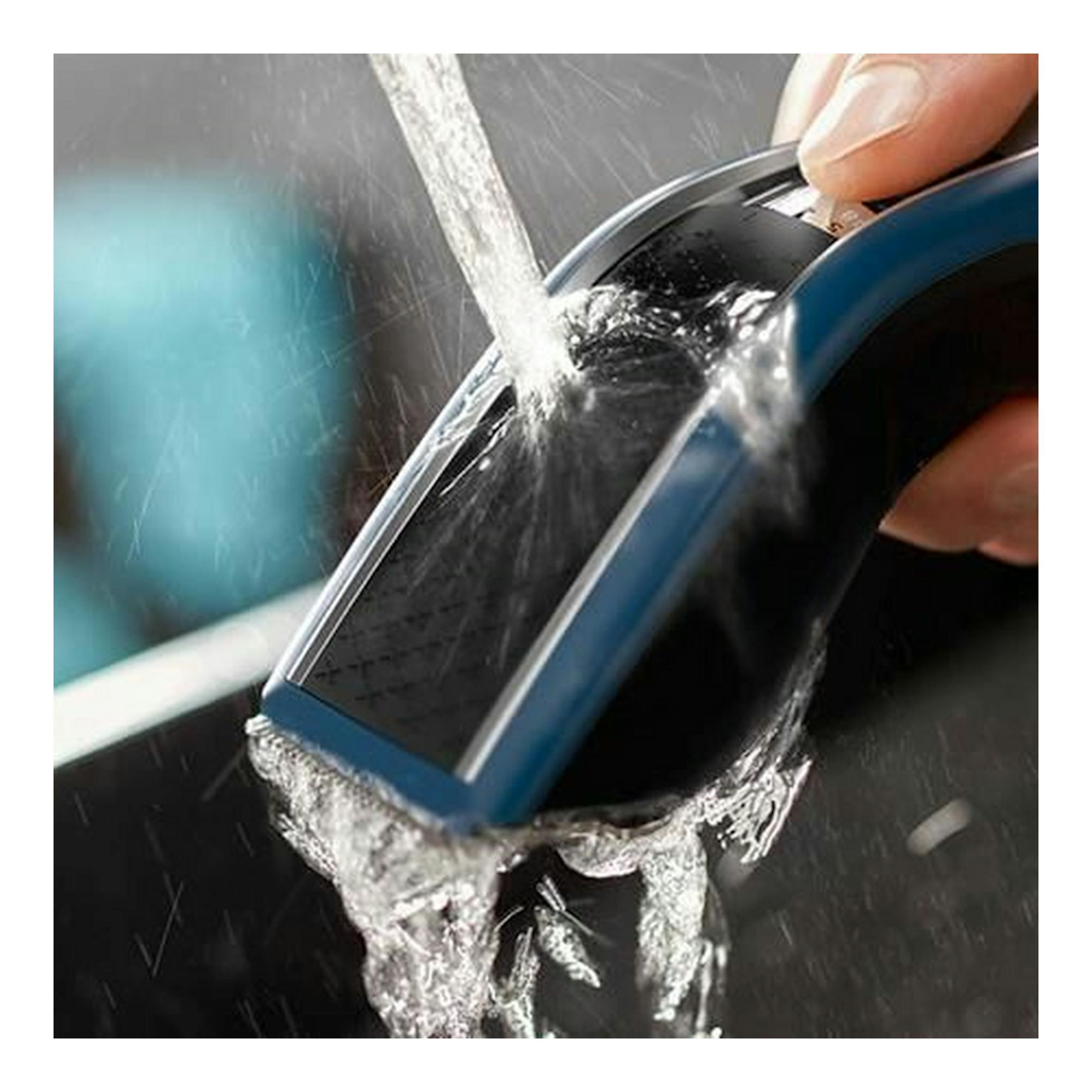 Cortapelo Philips HC5612/15 azul y negro, en primer plano, bajo un chorro de agua.