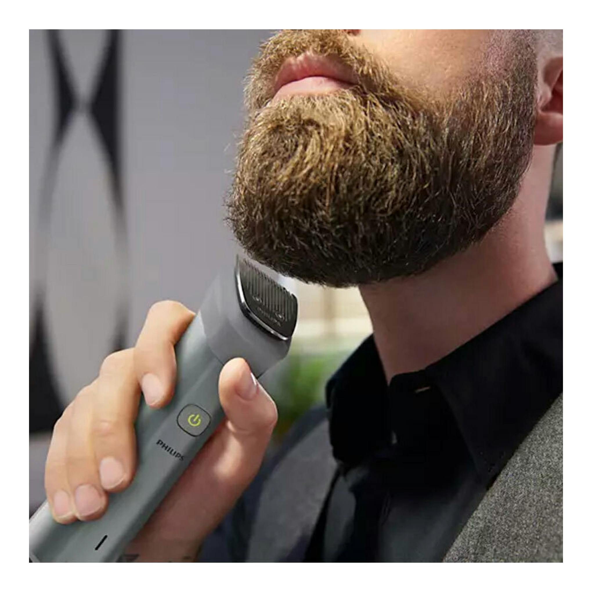Afeitadora/cortapelo Philips MG5940/15 en mano, recortando la barba de un hombre, vista frontal.