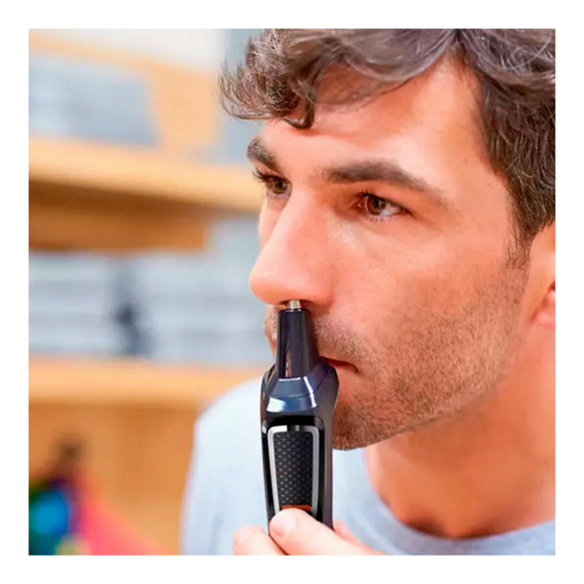 Hombre usando una afeitadora/cortapelos Philips MG3730/15 negra para recortar el vello nasal, vista lateral.