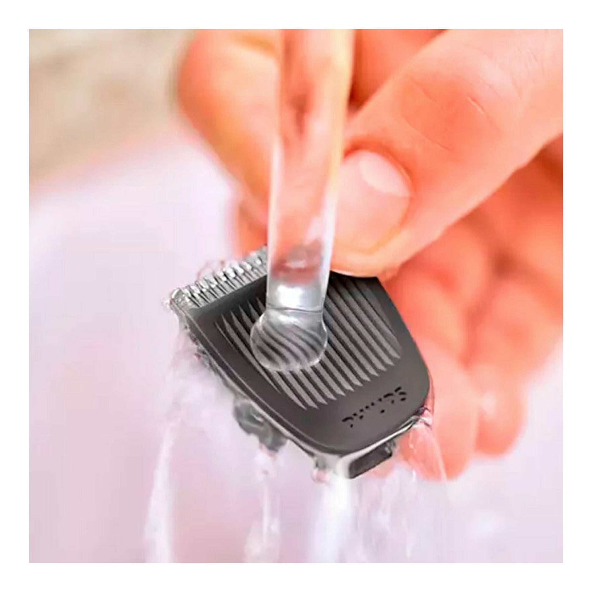 Afeitadora/cortapelos Philips MG3730/15 negra, en primer plano, enjuagándose bajo agua corriente.