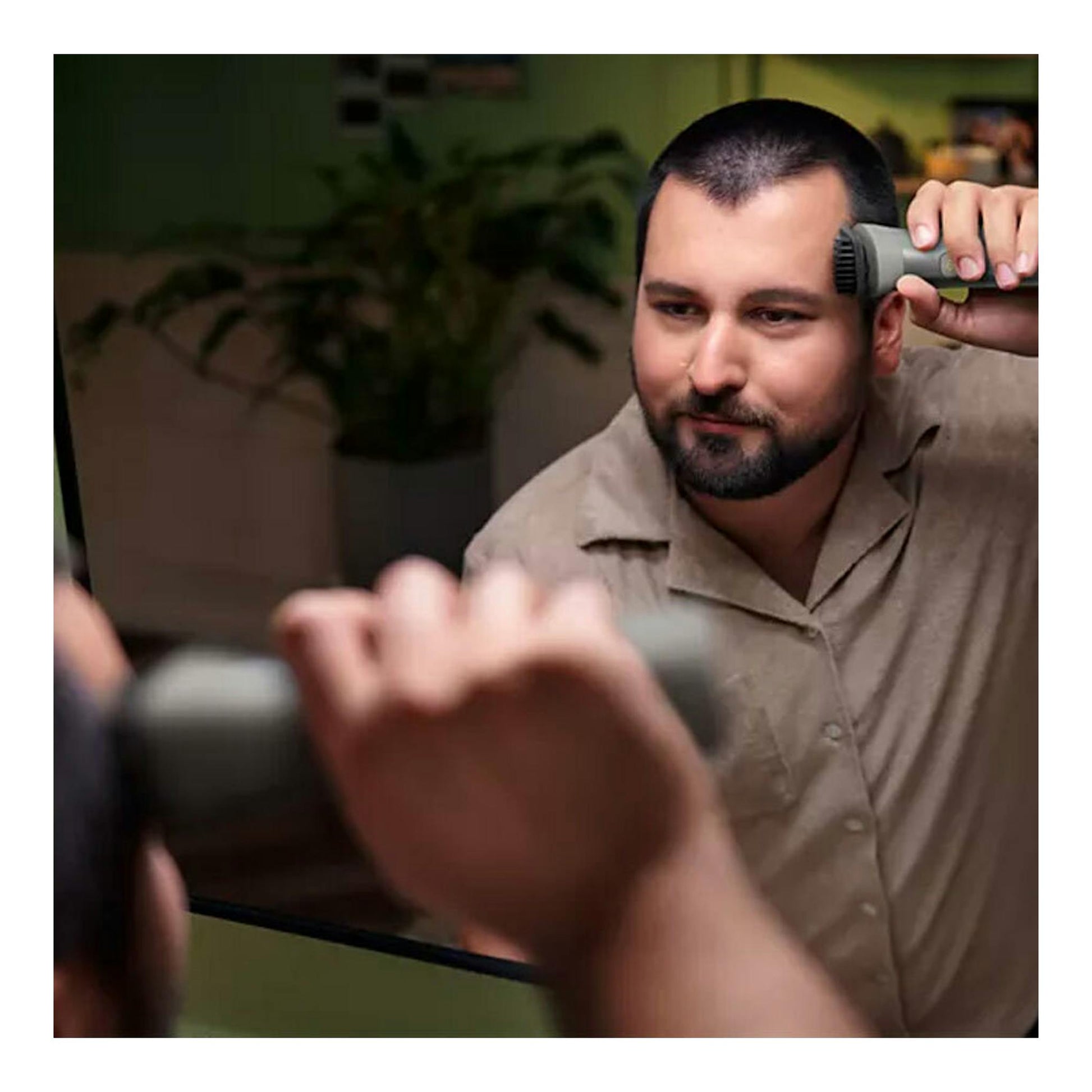Philips MG5940/15: hombre recortándose el cabello frente al espejo con afeitadora gris.
