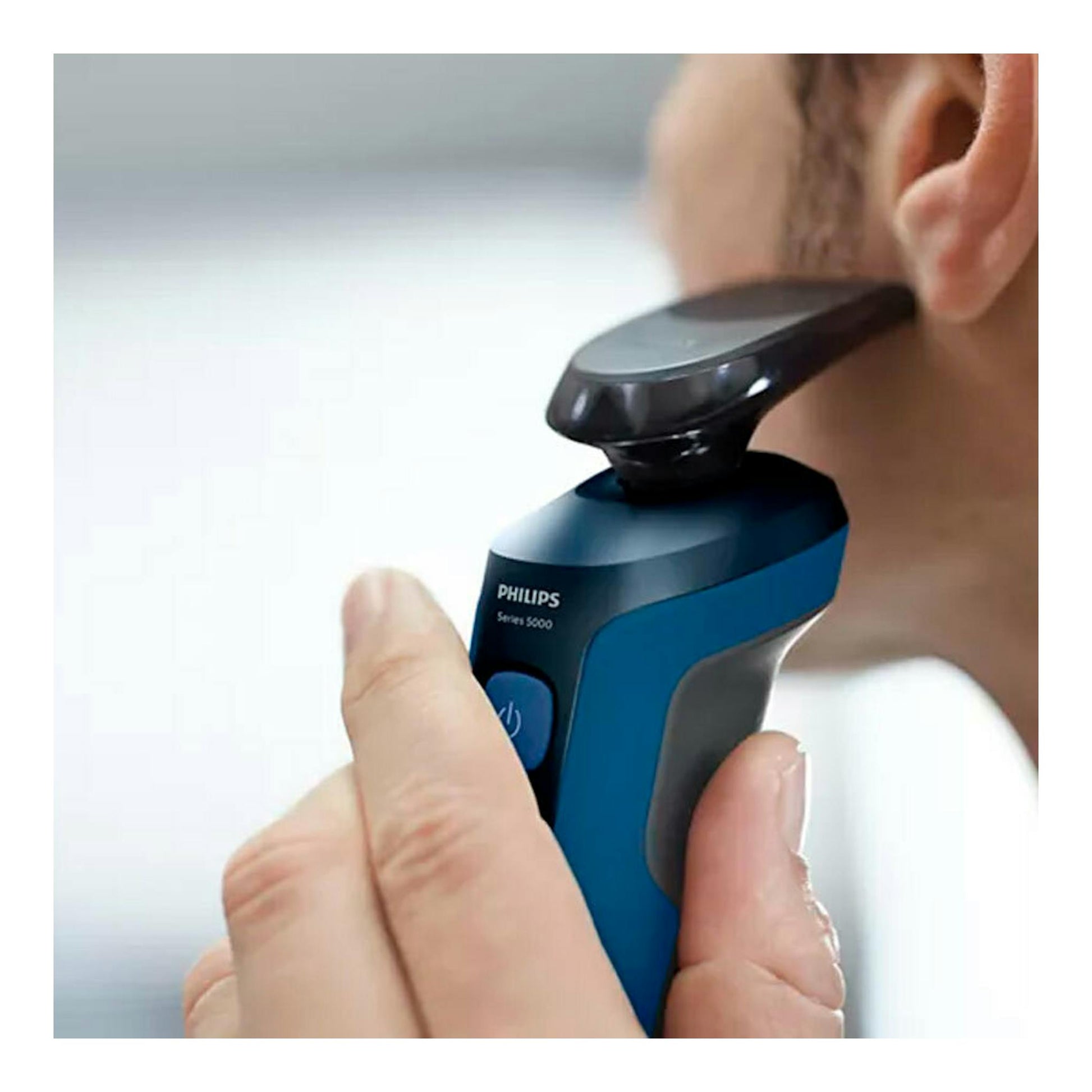 Afeitadora Philips S5466/17 azul y negra, en primer plano, apoyada en el cuello de una persona.