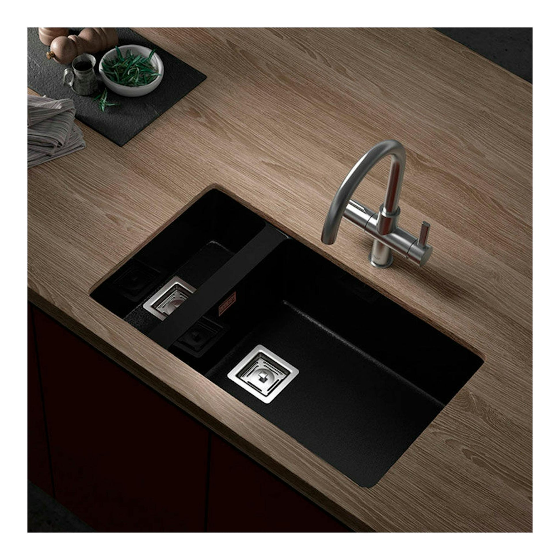 Fregadero Poalgi Zie 70 negro brillo, vista cenital inclinada, doble seno en encimera de madera con grifo.