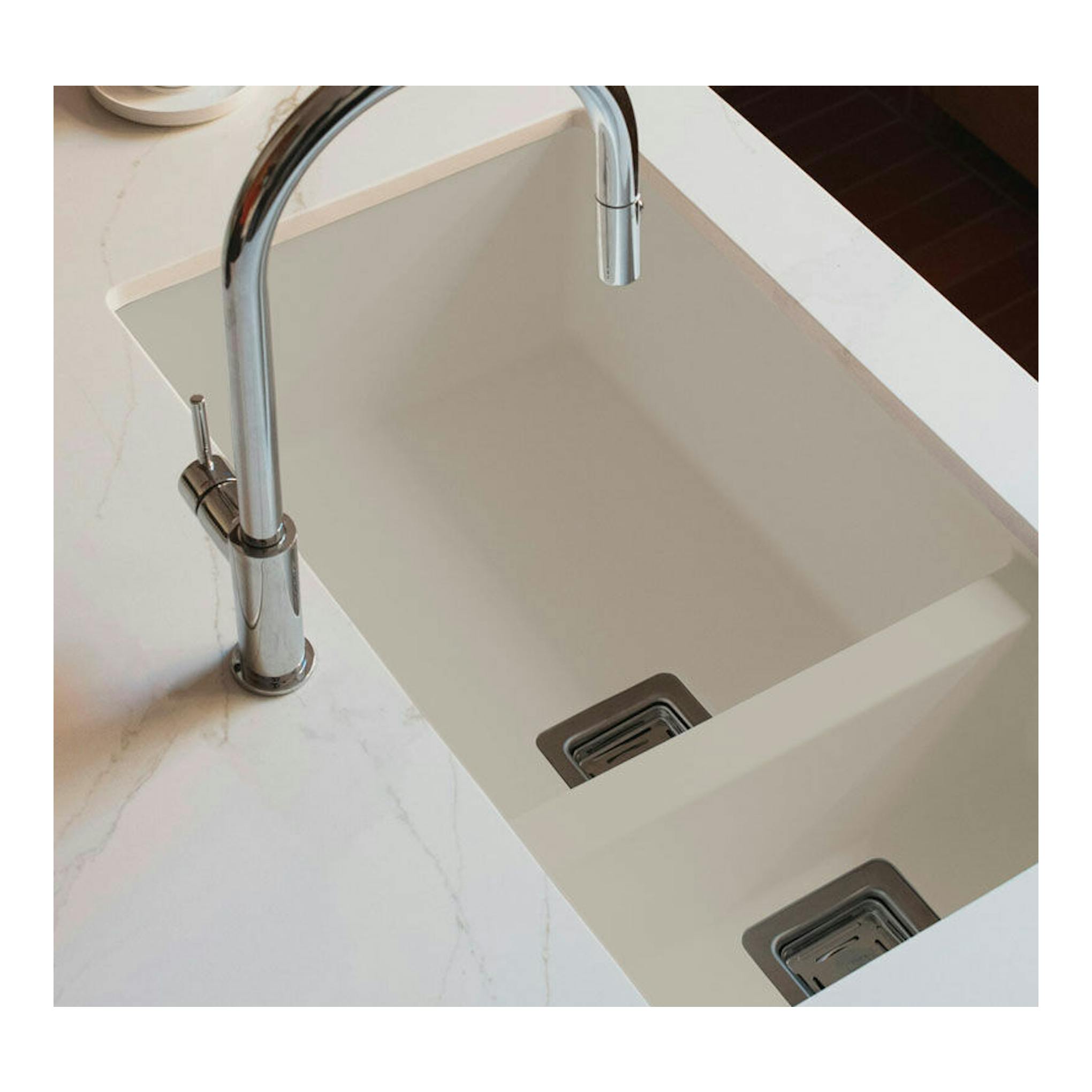 Fregadero Poalgi Zie 70 beige, vista cenital, integrado en encimera blanca con grifo cromado.