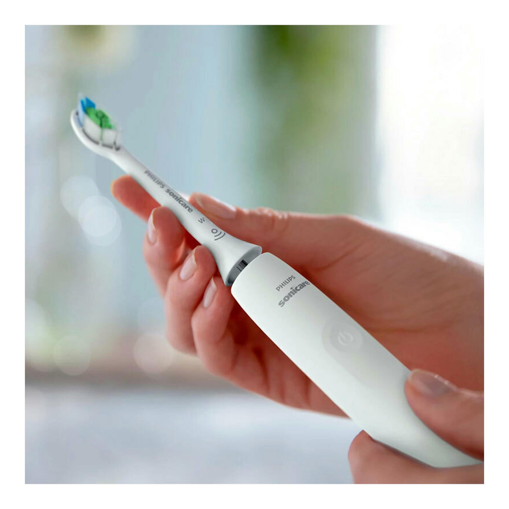 Cepillo dental eléctrico Philips Sonicare HX3681/33 blanco, sujetado con la mano en vista frontal.