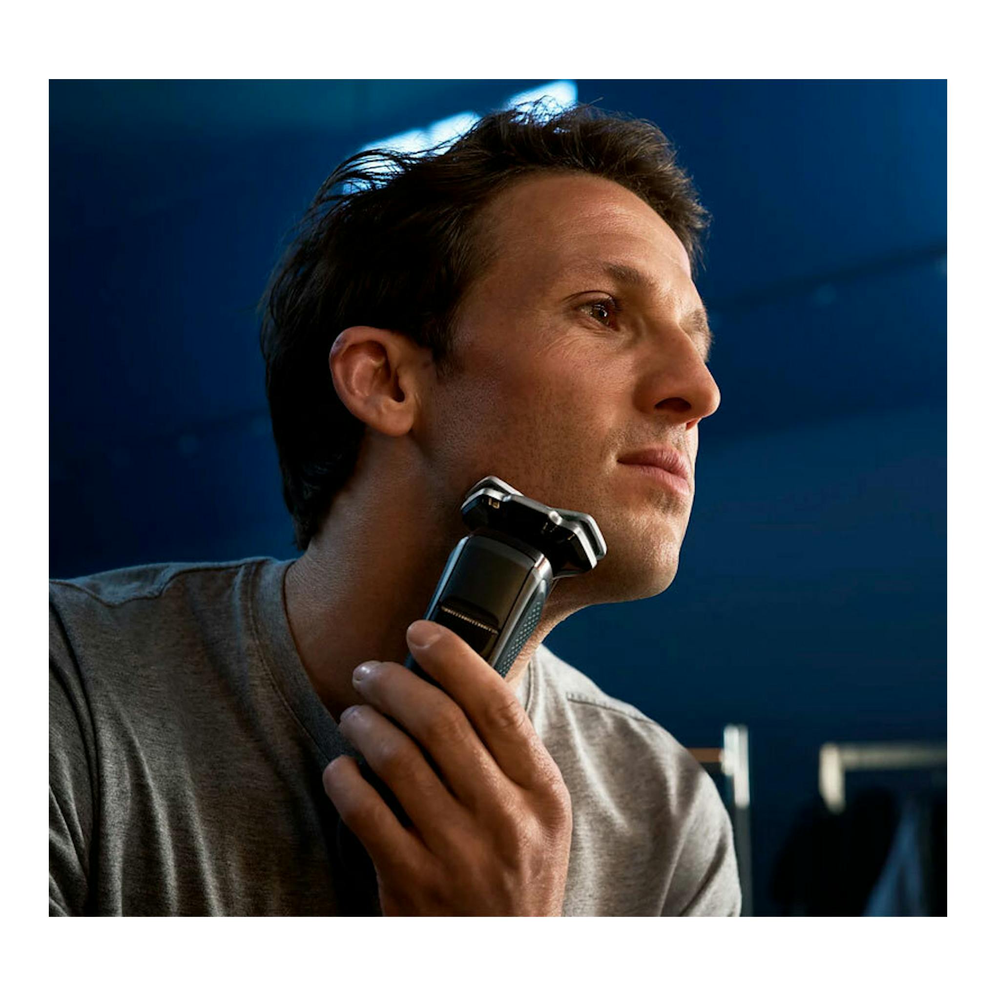 Afeitadora Philips S8697/35 en uso; hombre afeitándose el cuello en vista lateral.
