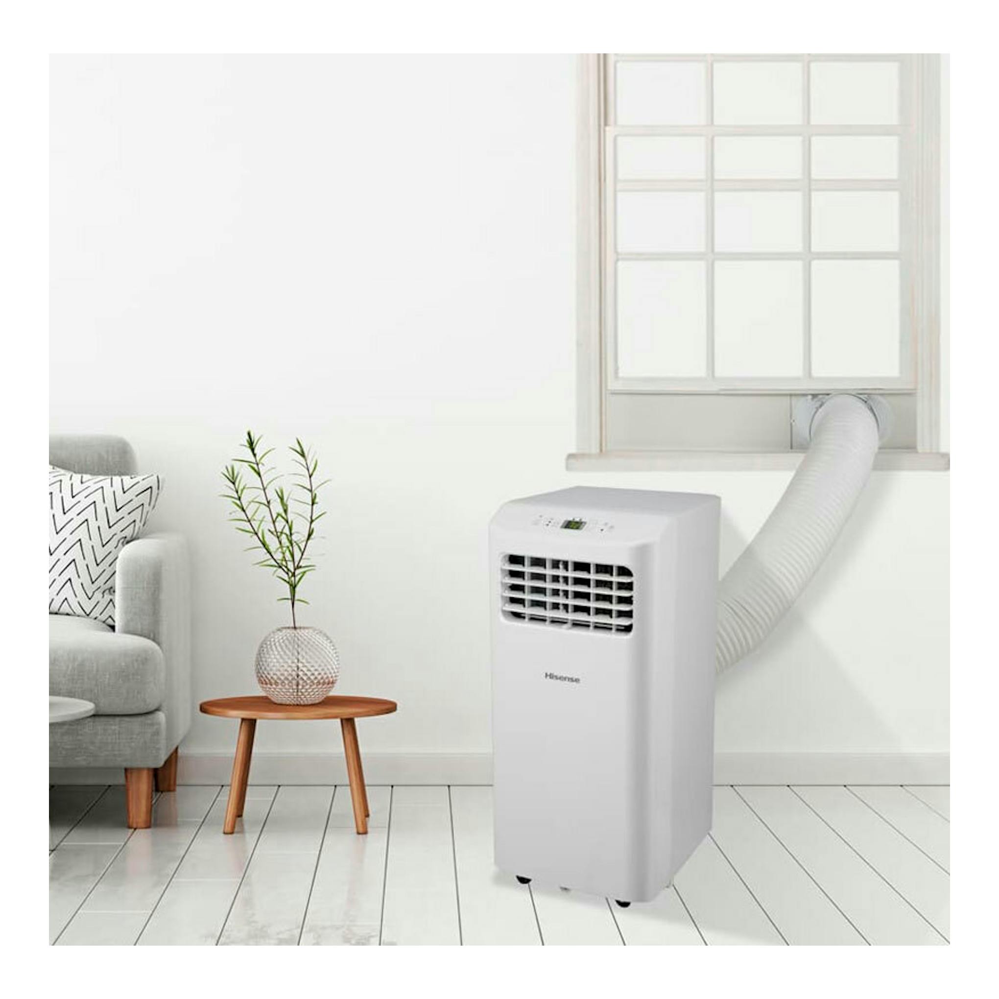 Aire acondicionado portátil Hisense APC09KV blanco, vista frontal, junto a una ventana con tubo de extracción.