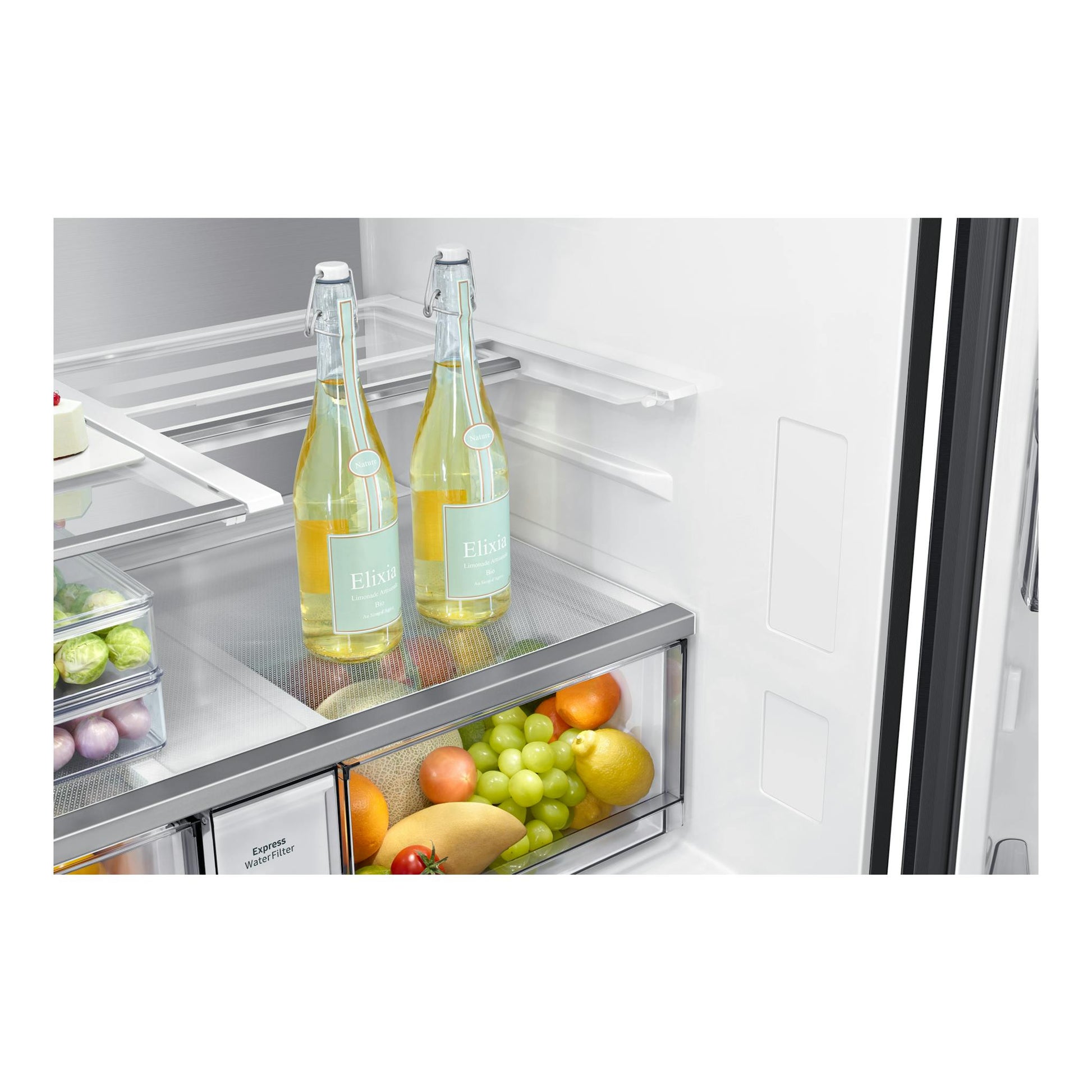 Interior de frigorífico Samsung RF65DG9H0EB1EF en vista frontal, con botellas, fruta y cajones transparentes.
