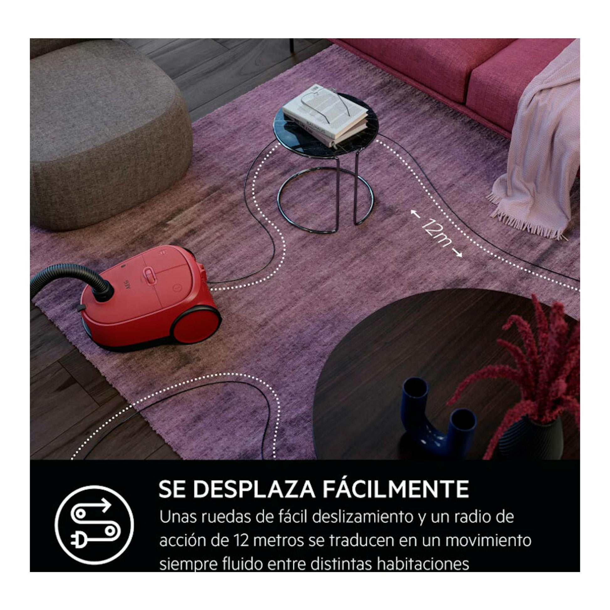 Aspirador de trineo AEG AB61C2DB rojo, vista en ángulo en un salón, junto a una alfombra.
