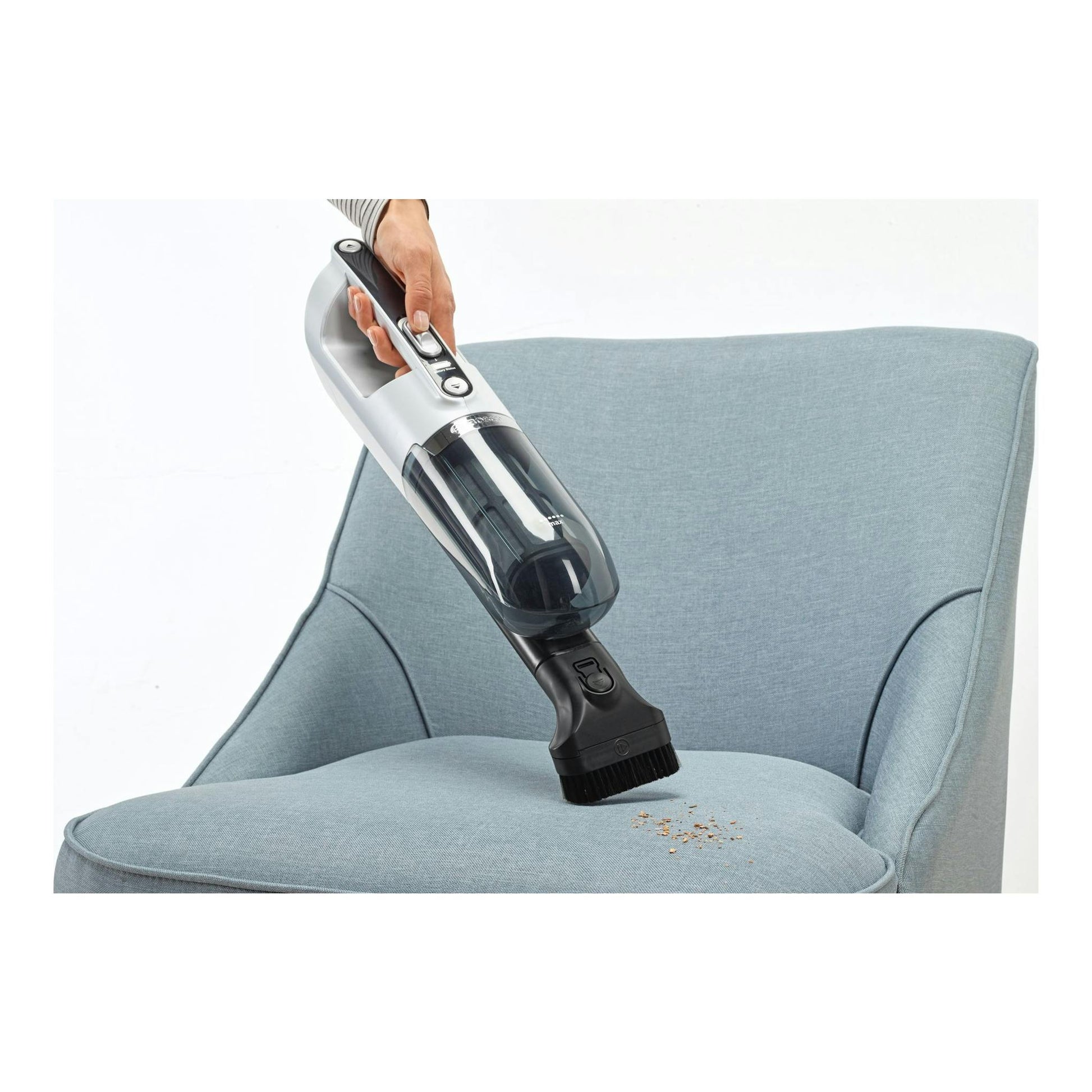 Aspirador escoba Bosch Flexxo BBH32551 blanco y negro, en uso sobre un sillón azul claro.