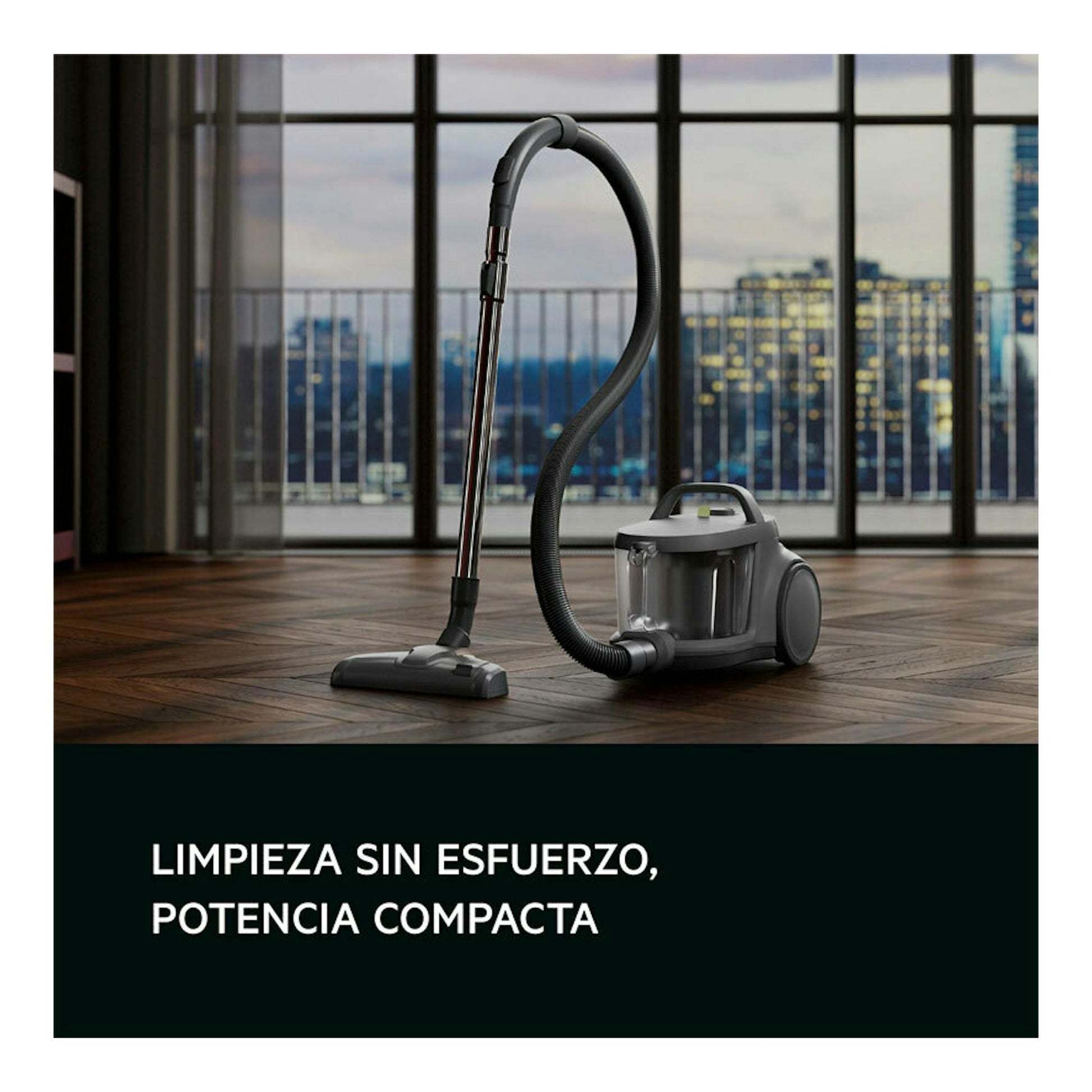 Aspirador sin bolsa AEG AL31C1DG gris, con manguera y boquilla, en vista frontal sobre suelo de madera.