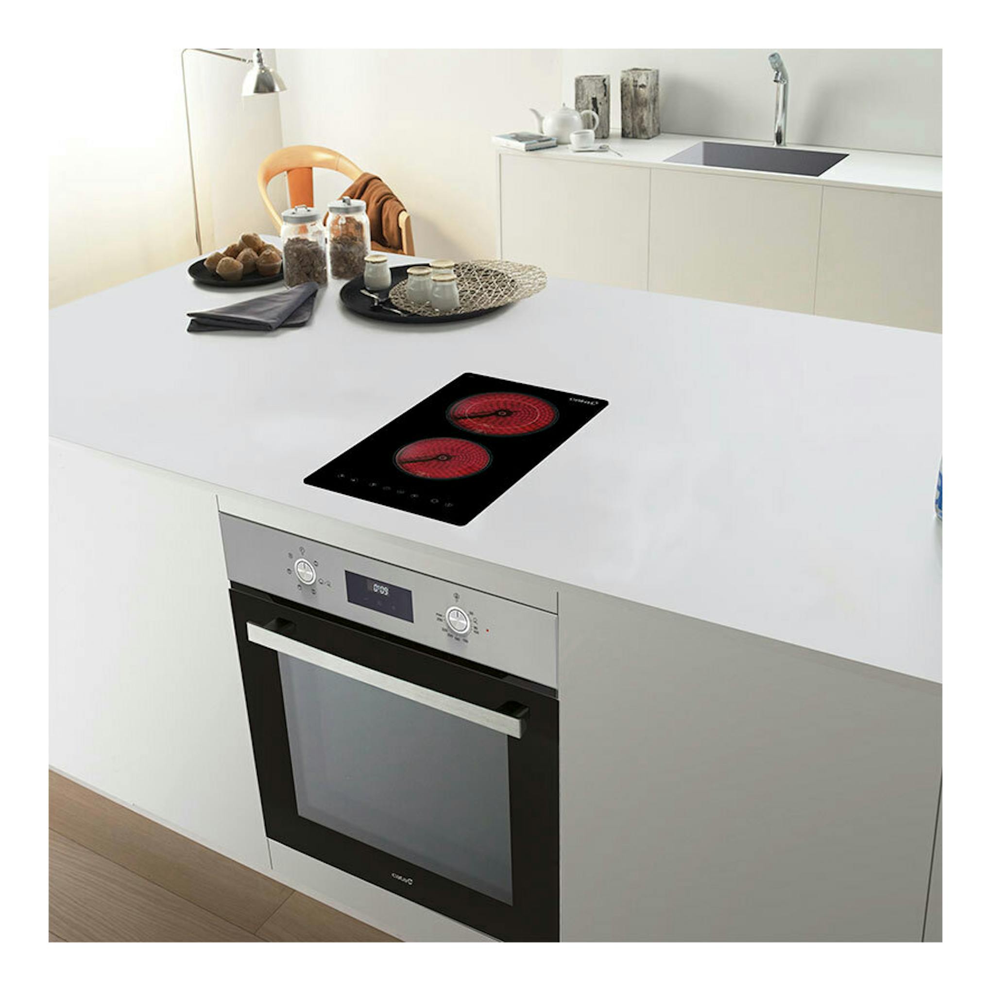 Placa vitrocerámica Cata TD3002 BK negra, vista superior inclinada, con dos zonas rojas.