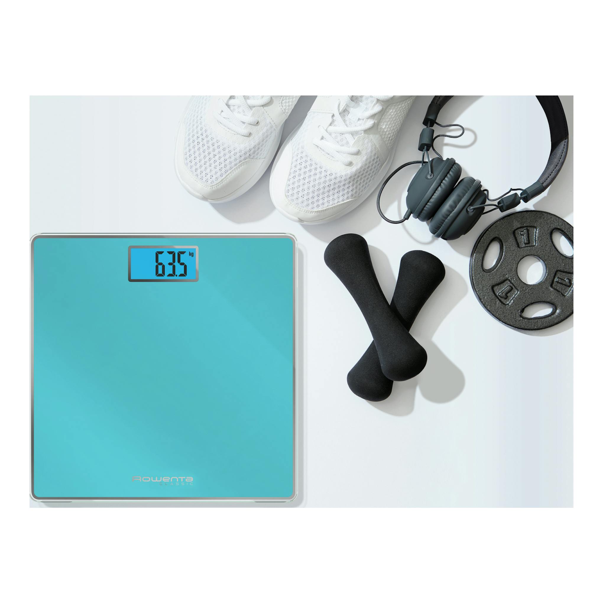 Báscula digital Rowenta BS1500V0 turquesa, vista superior, con 63,5 kg en pantalla y material de fitness alrededor.