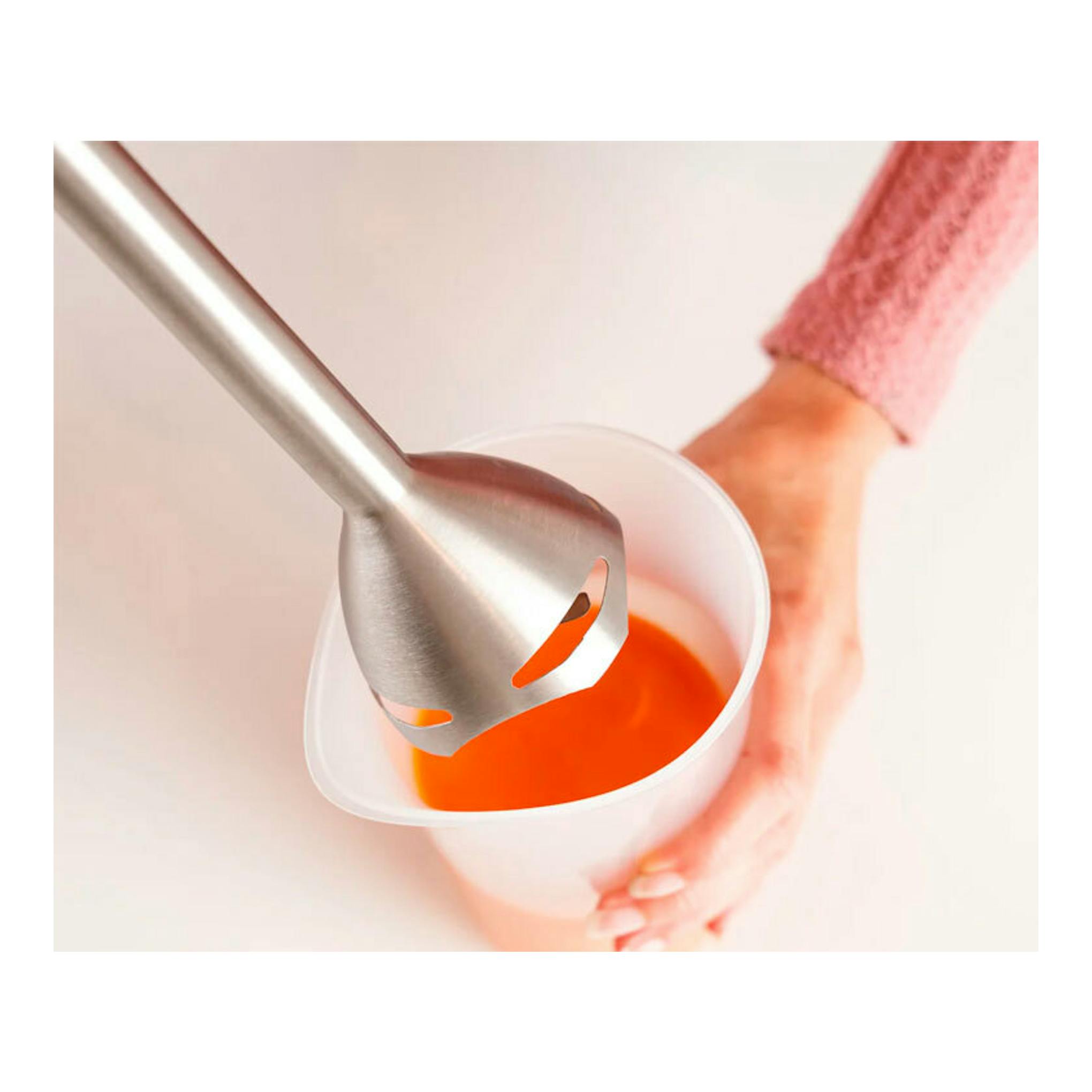 Batidora Taurus Bapi 1200 Pure de acero inoxidable, vista cenital, batiendo líquido naranja en un vaso.