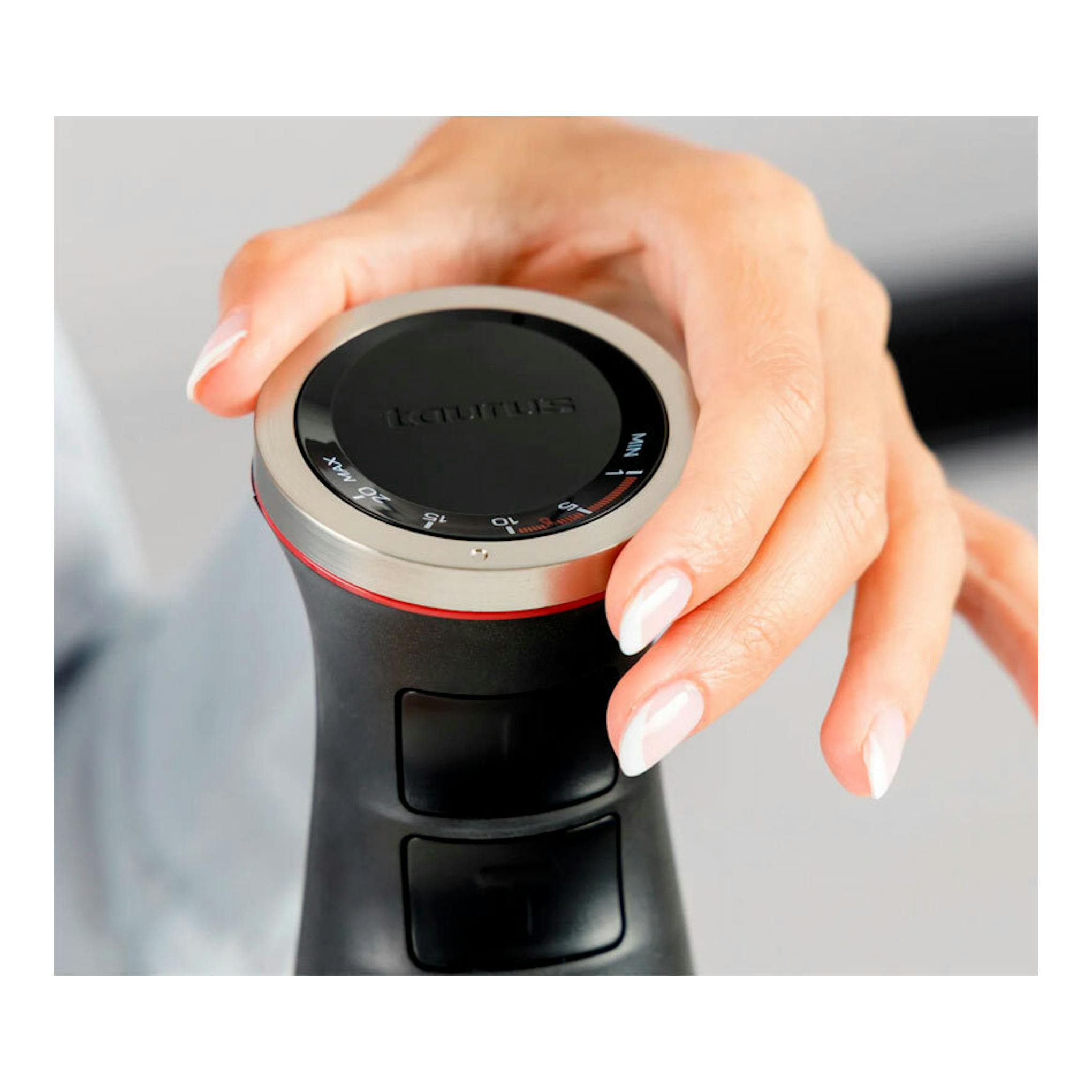 Batidora de mano Taurus Bapi 1500 Plus Inox negra, vista superior con mando metálico y una mano sujetándola.