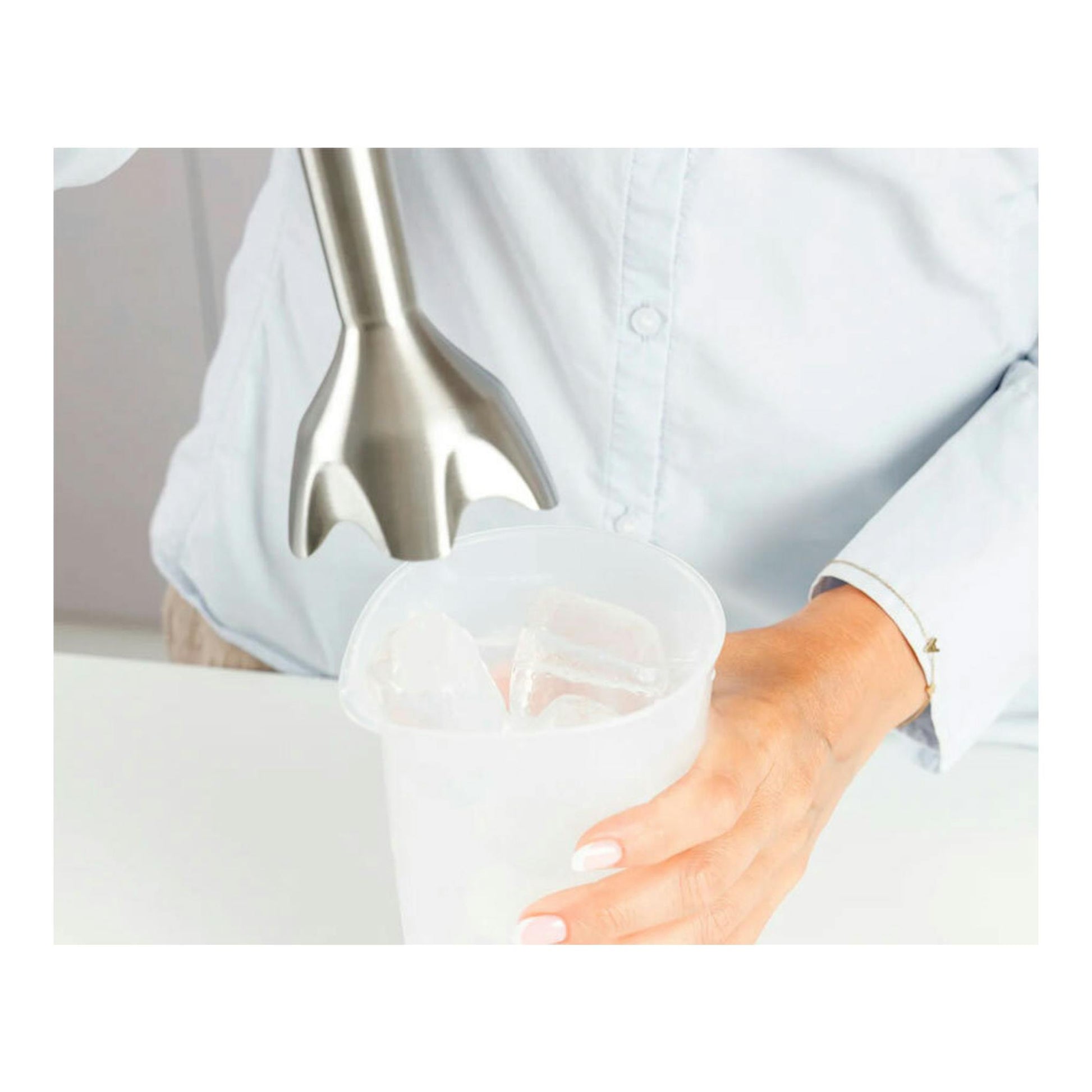 Batidora de mano Taurus Bapi 1500 Plus Inox de acero inoxidable sobre vaso medidor, primer plano.