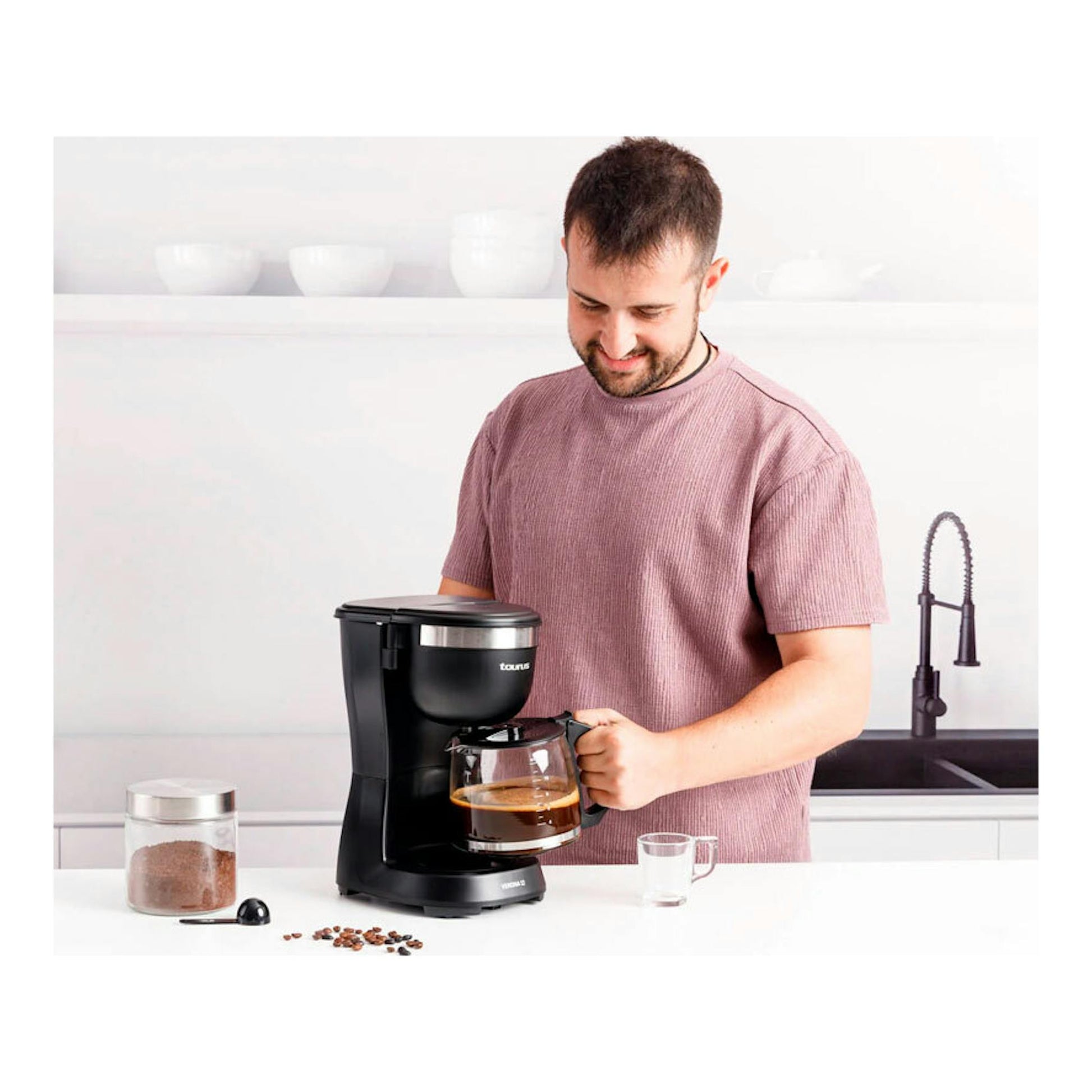 Cafetera de goteo Taurus Verona 12 negra, vista frontal, con jarra de vidrio sobre una encimera.