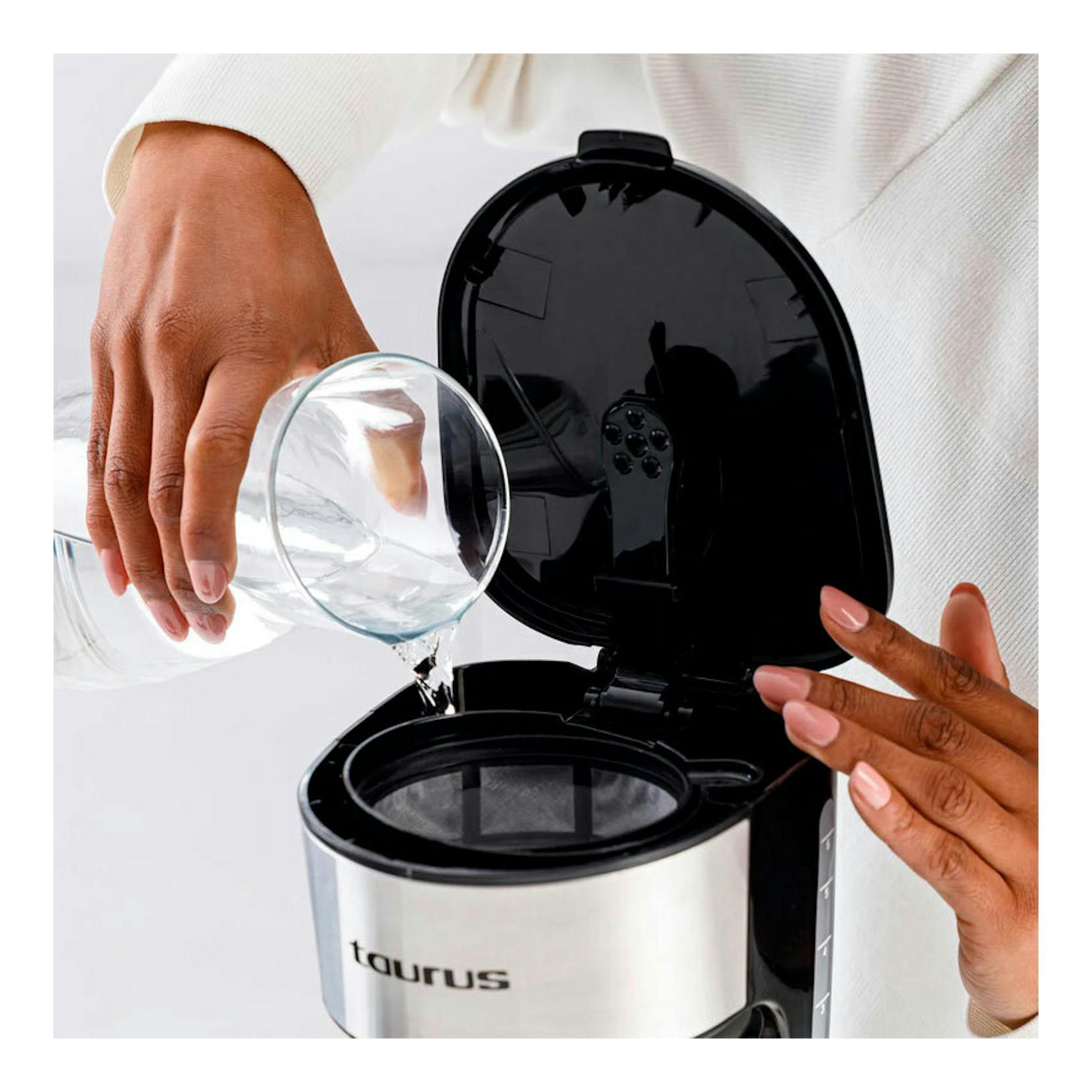 Cafetera de goteo Taurus Verona 6 Inox abierta, vista frontal, con agua vertiéndose en el depósito.