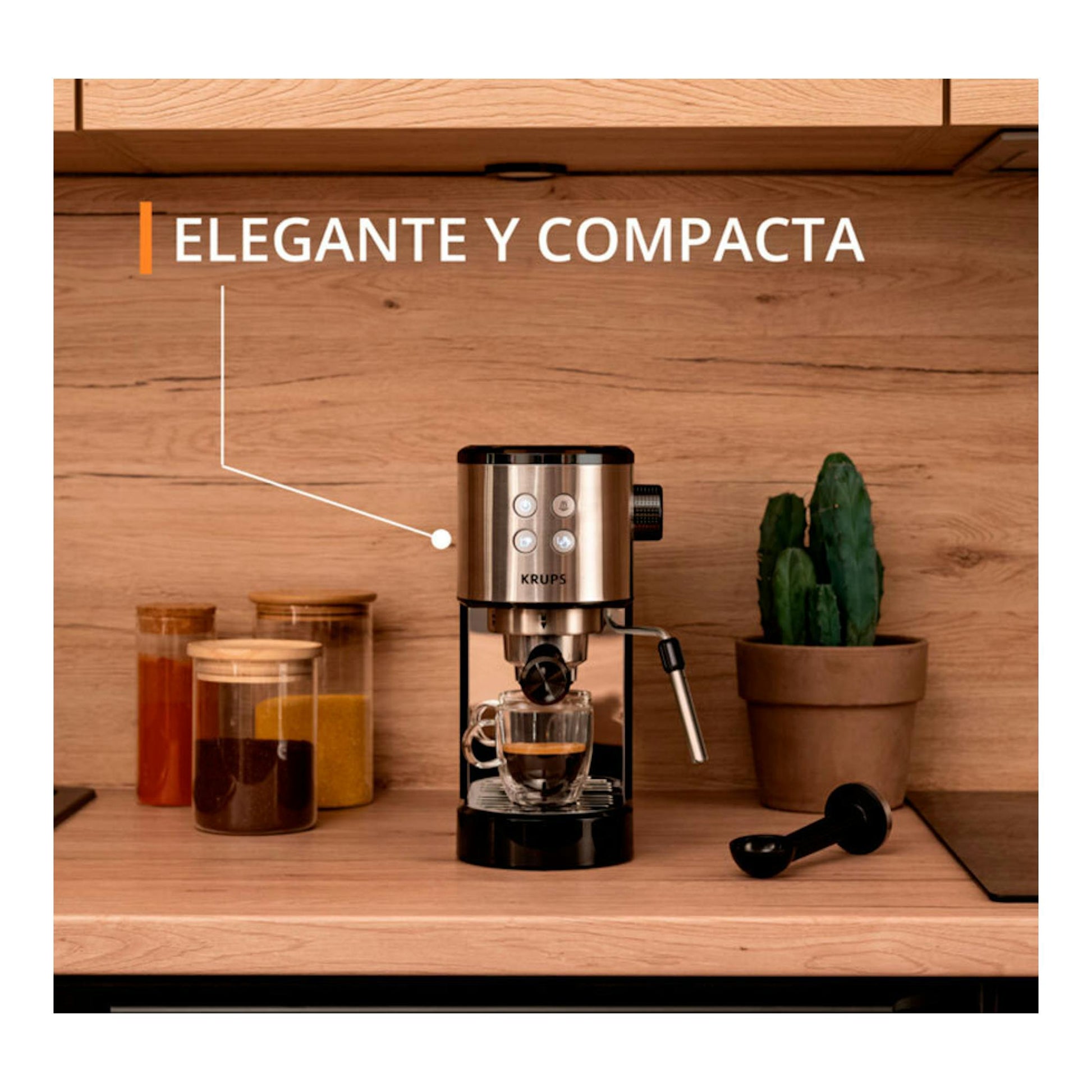 Cafetera espresso Krups XP444C10 negra y plateada, vista frontal sobre encimera de madera.
