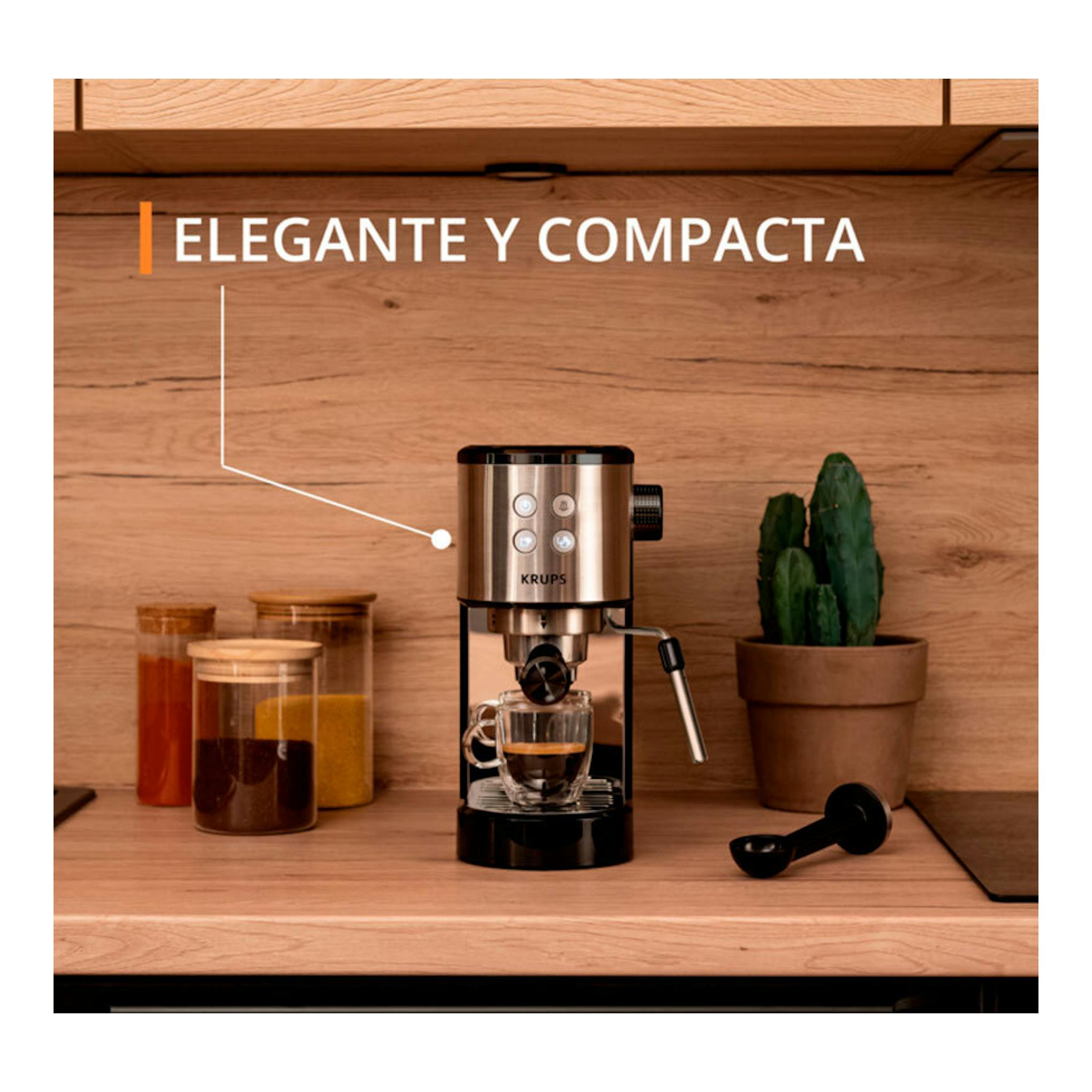 Cafetera espresso Krups XP444C10 negra y plateada, vista frontal sobre encimera de madera.