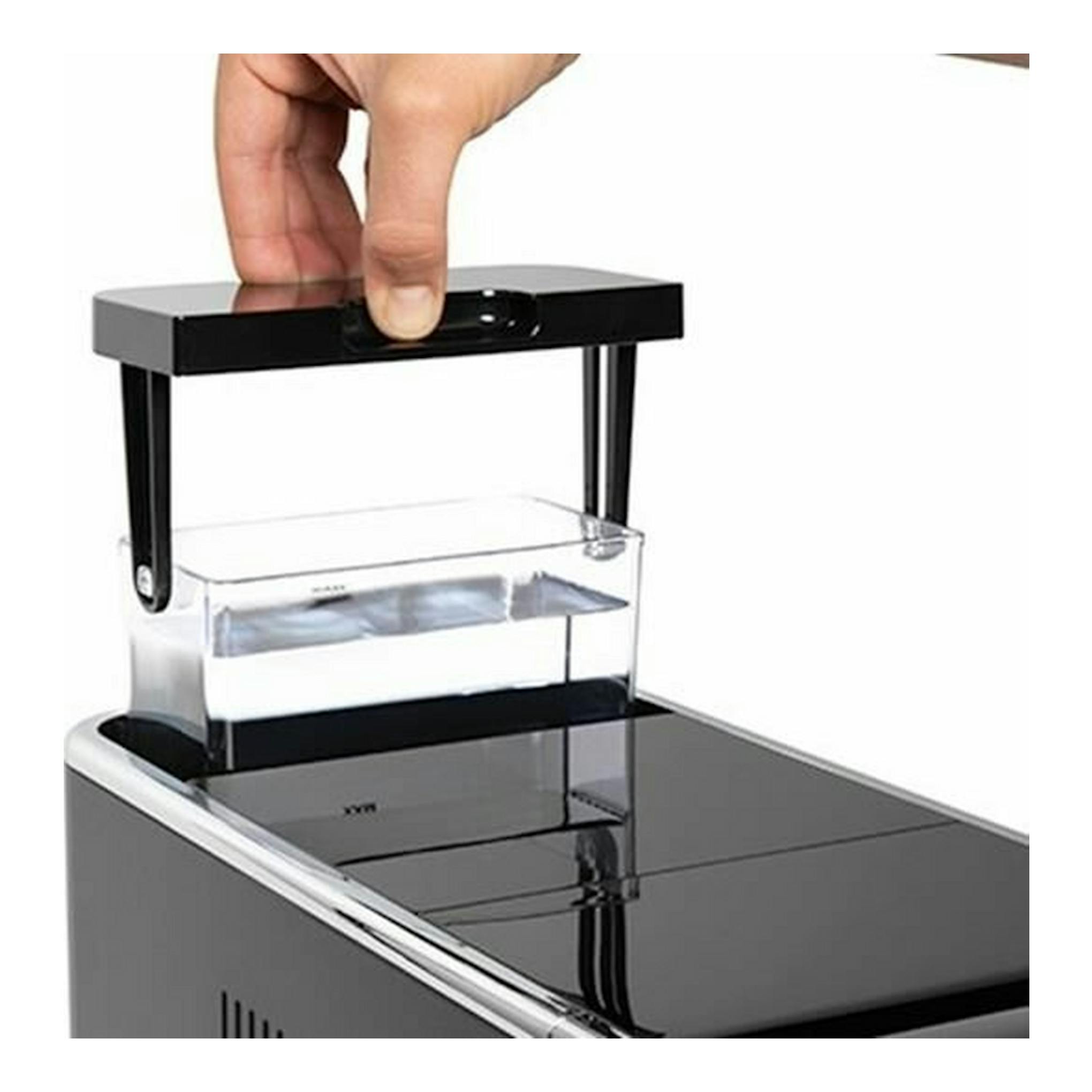 Cafetera espresso Solac CA4810 negra, en primer plano, con depósito transparente y una mano ajustando la tapa.