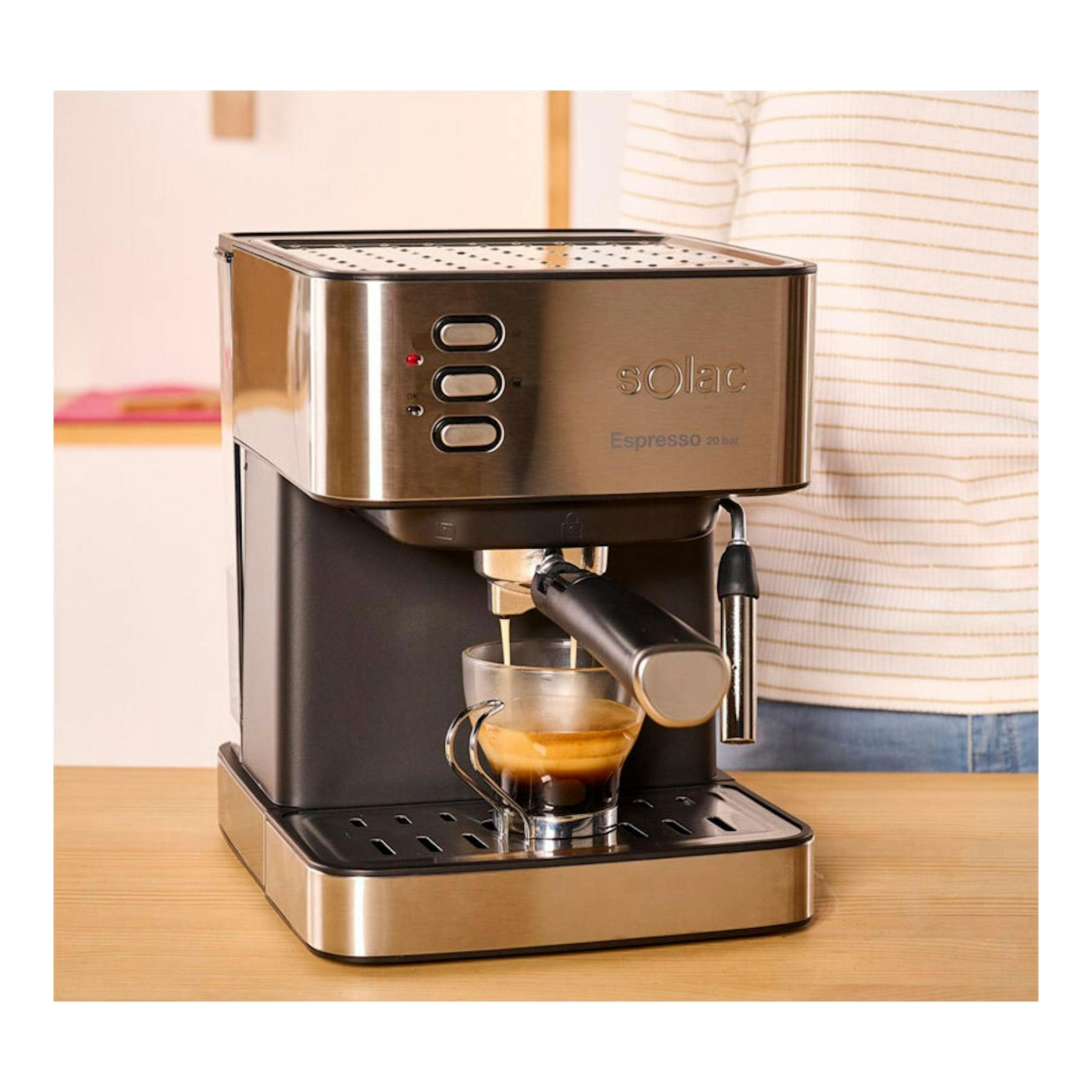 Cafetera espresso Solac CE4481 negra y acero inoxidable, vista frontal, preparando café en taza de vidrio.