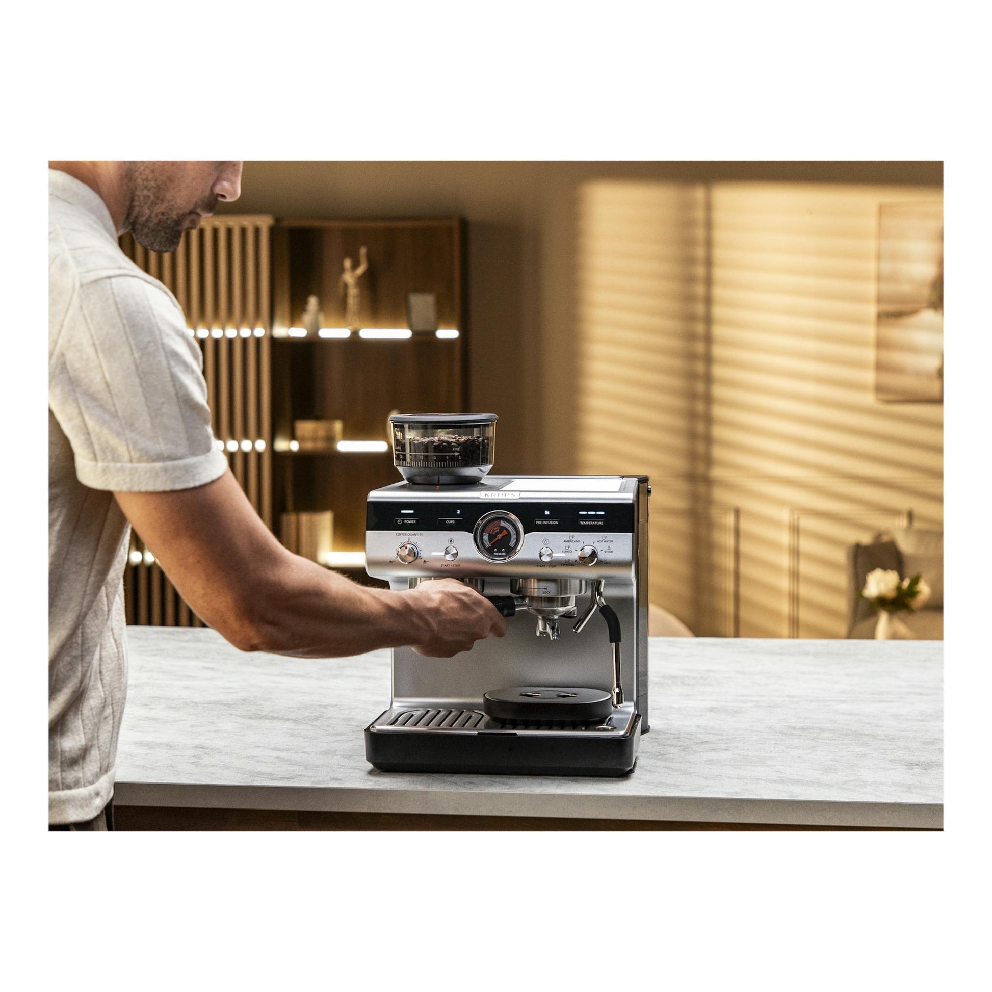 Cafetera espresso Krups XP801T10 plateada y negra, vista frontal, con molinillo integrado sobre encimera.