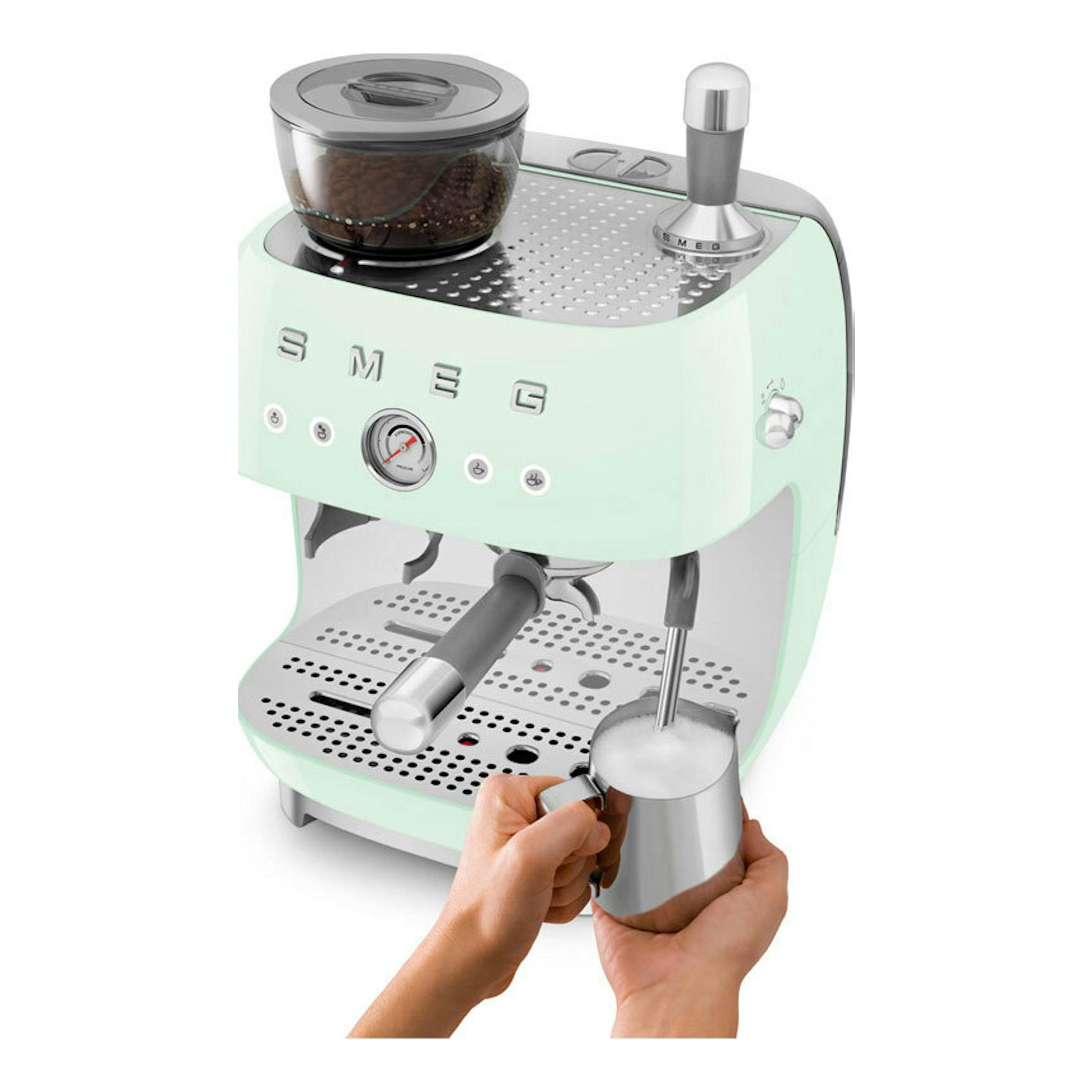 Cafetera espresso Smeg EGF03PGEU verde menta, vista frontal tres cuartos, con vaporizador y manos espumando leche.