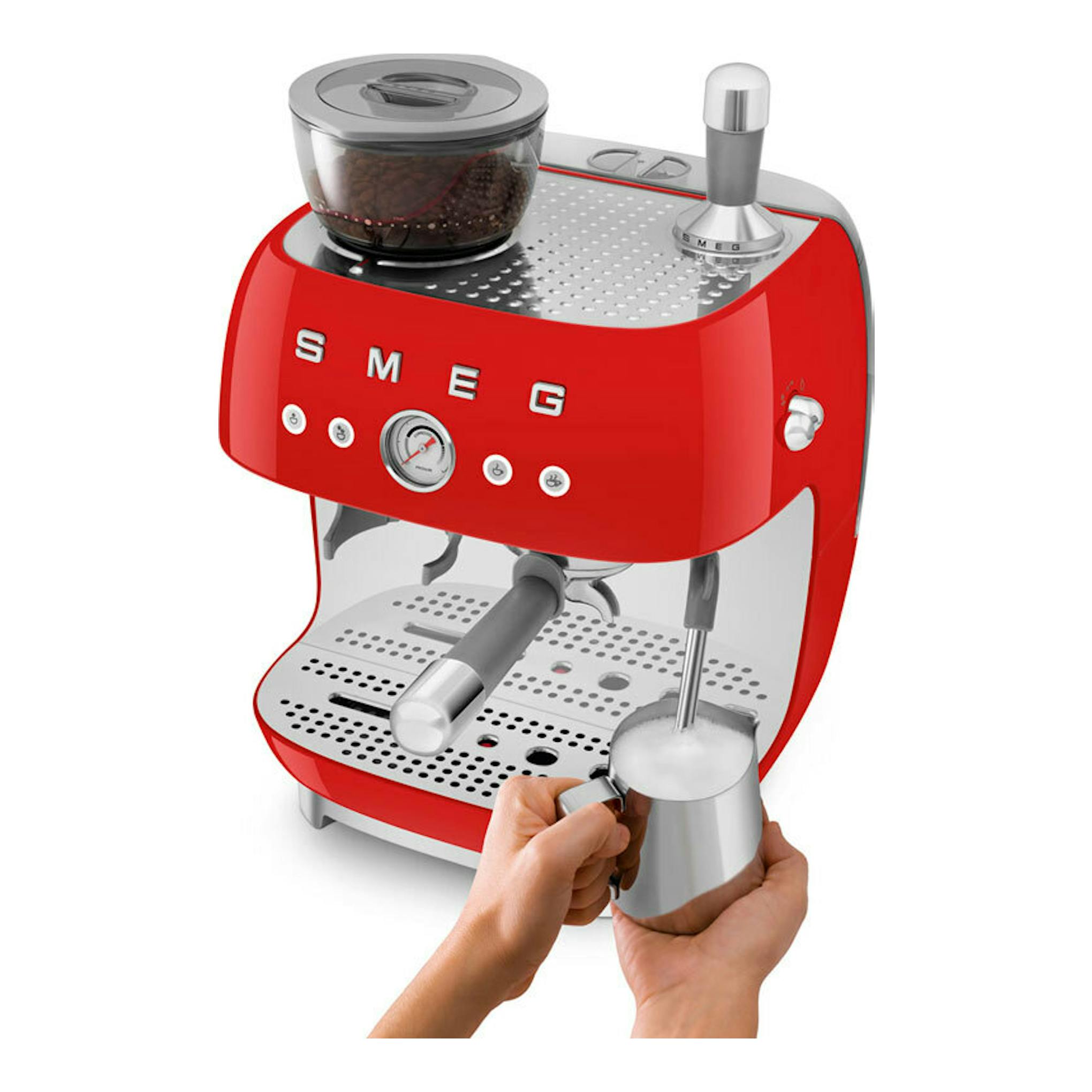 Cafetera espresso Smeg EGF03RDEU roja, vista frontal tres cuartos, con molinillo superior y manos espumando leche.
