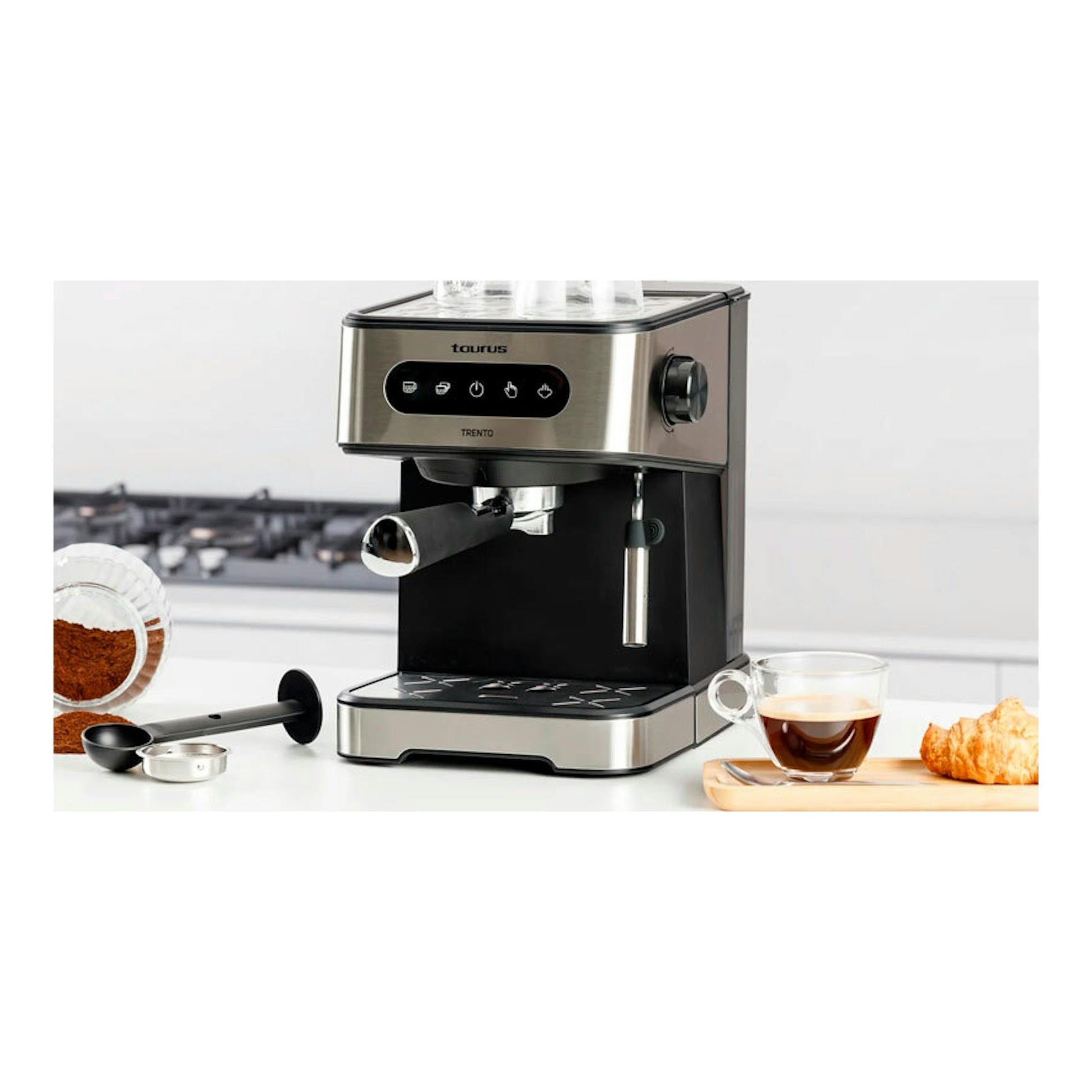 Cafetera espresso Taurus Trento de acero inoxidable y negro, vista frontal tres cuartos, con taza y accesorios.