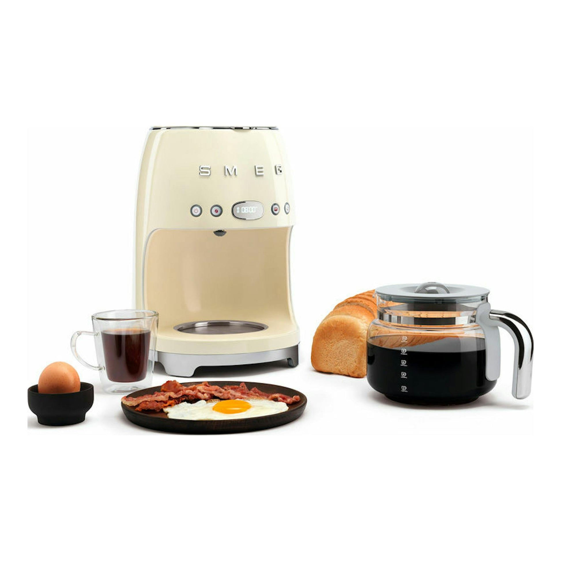 Cafetera de goteo Smeg DCF02CREU crema, vista frontal, con jarra, taza y pan.