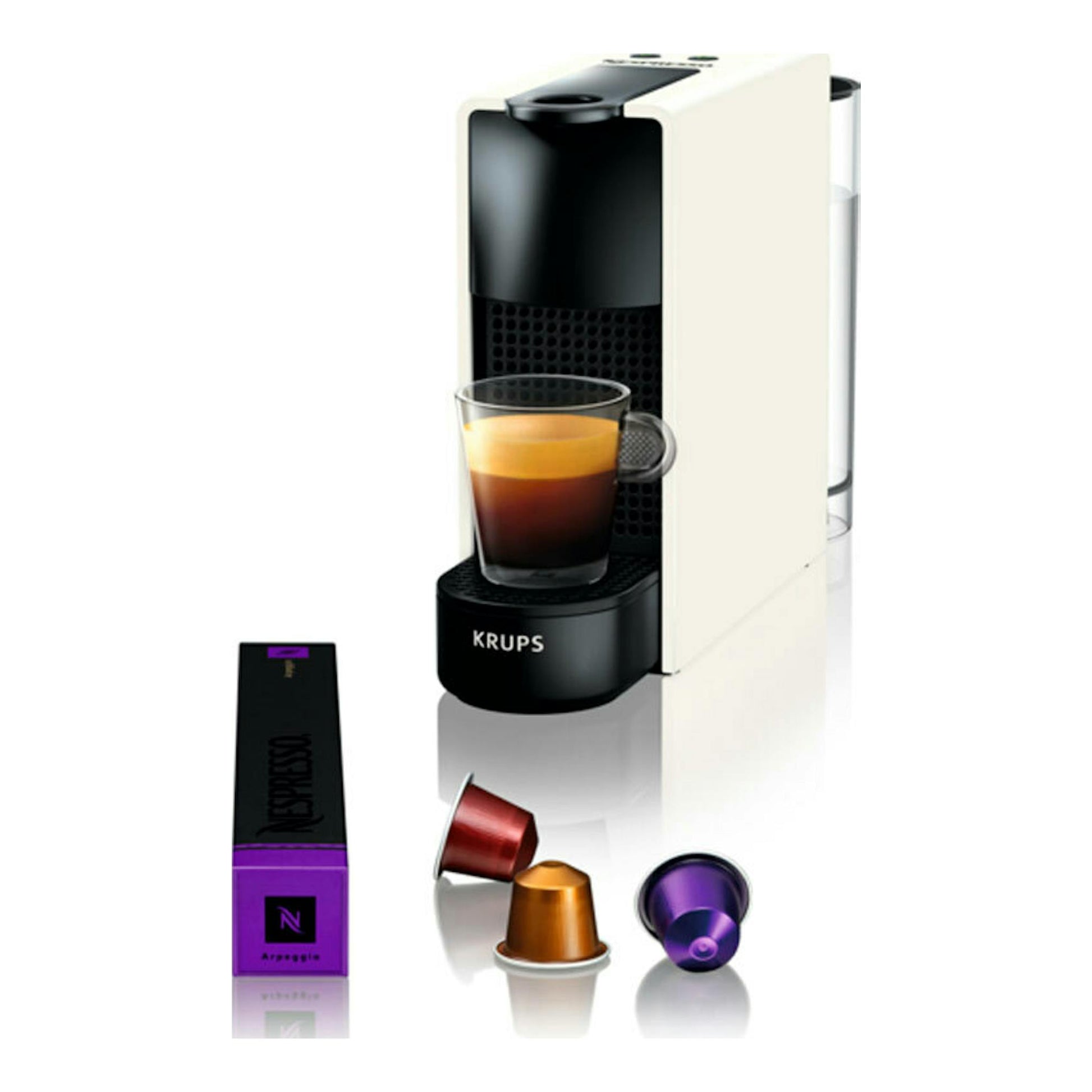 Krups Nespresso XN1101RD blanca y negra, vista frontal en tres cuartos, con taza de café y cápsulas.