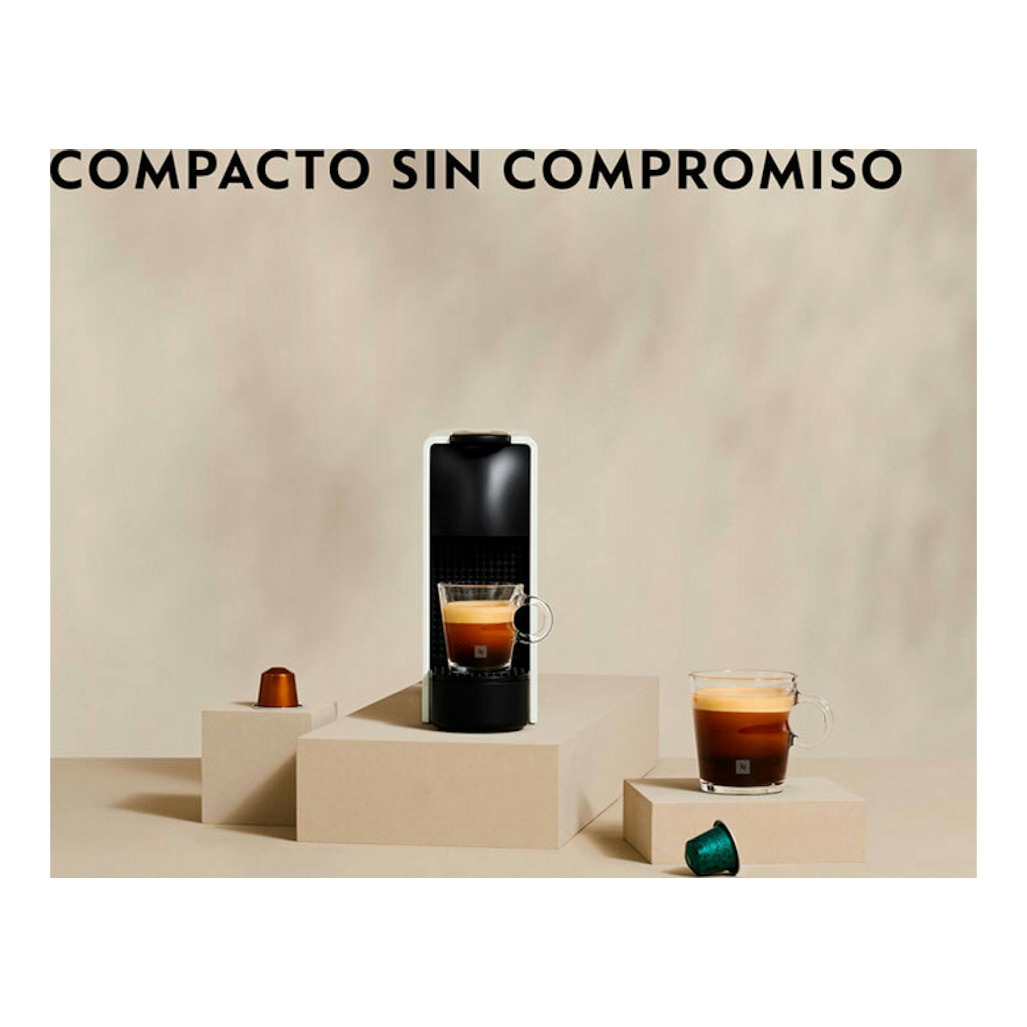 Cafetera Nespresso Krups XN1101RD negra, vista frontal, con taza de café y cápsulas.