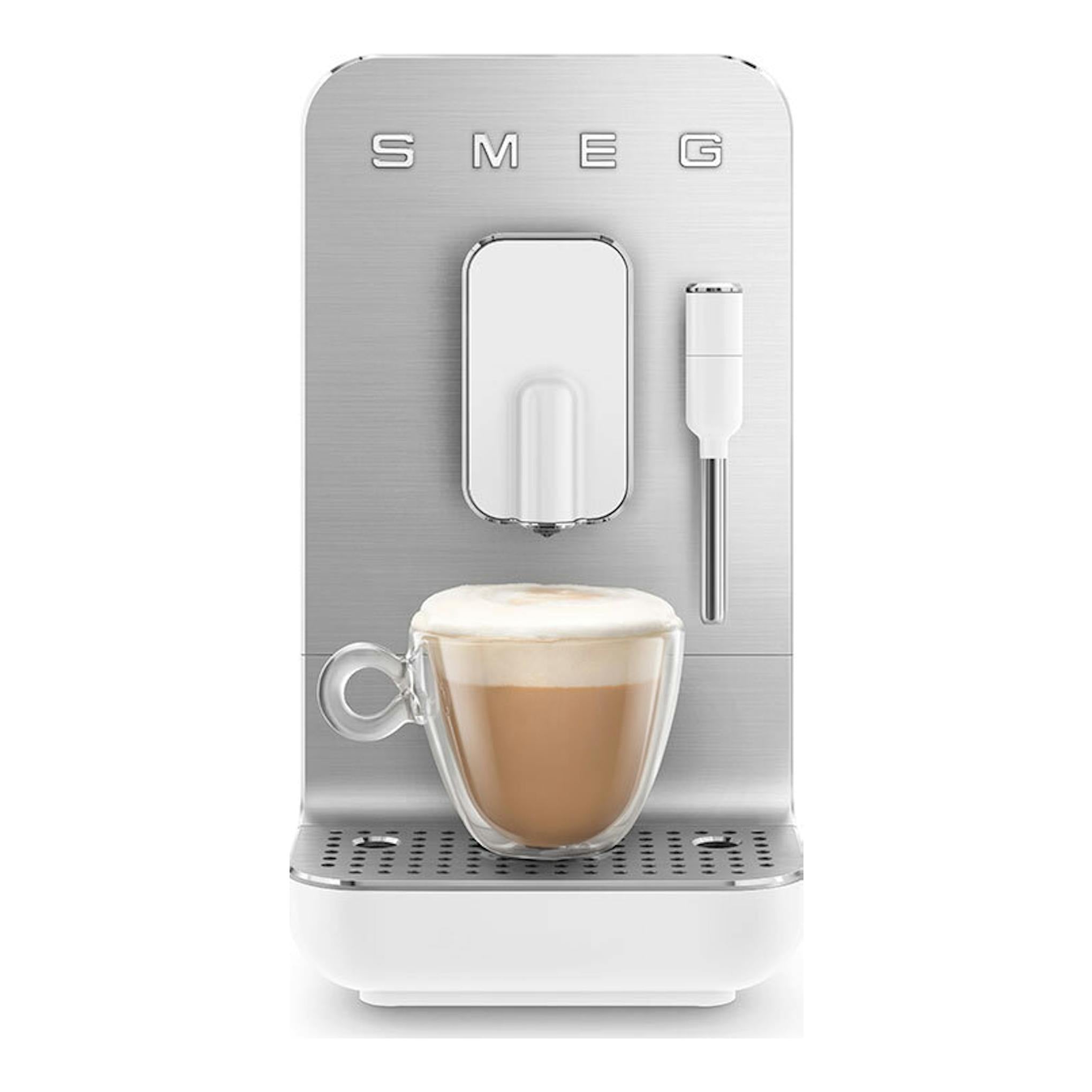 Cafetera superautomática Smeg BCC12WHMEU, vista frontal, blanca y acero, con taza de café y vaporizador.