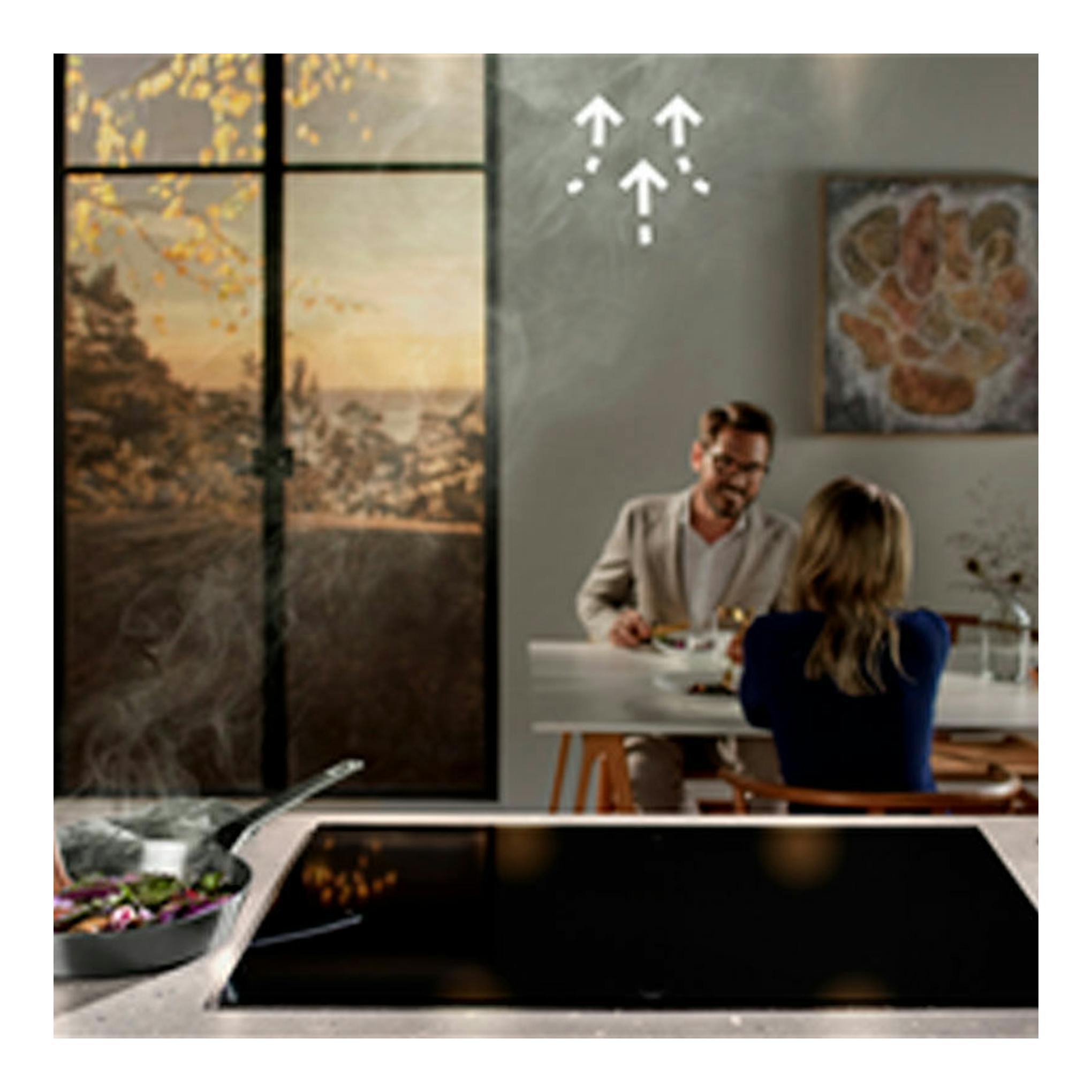Campana de isla Electrolux LFI769X inox sobre cocina con isla y placa negra, vista frontal.