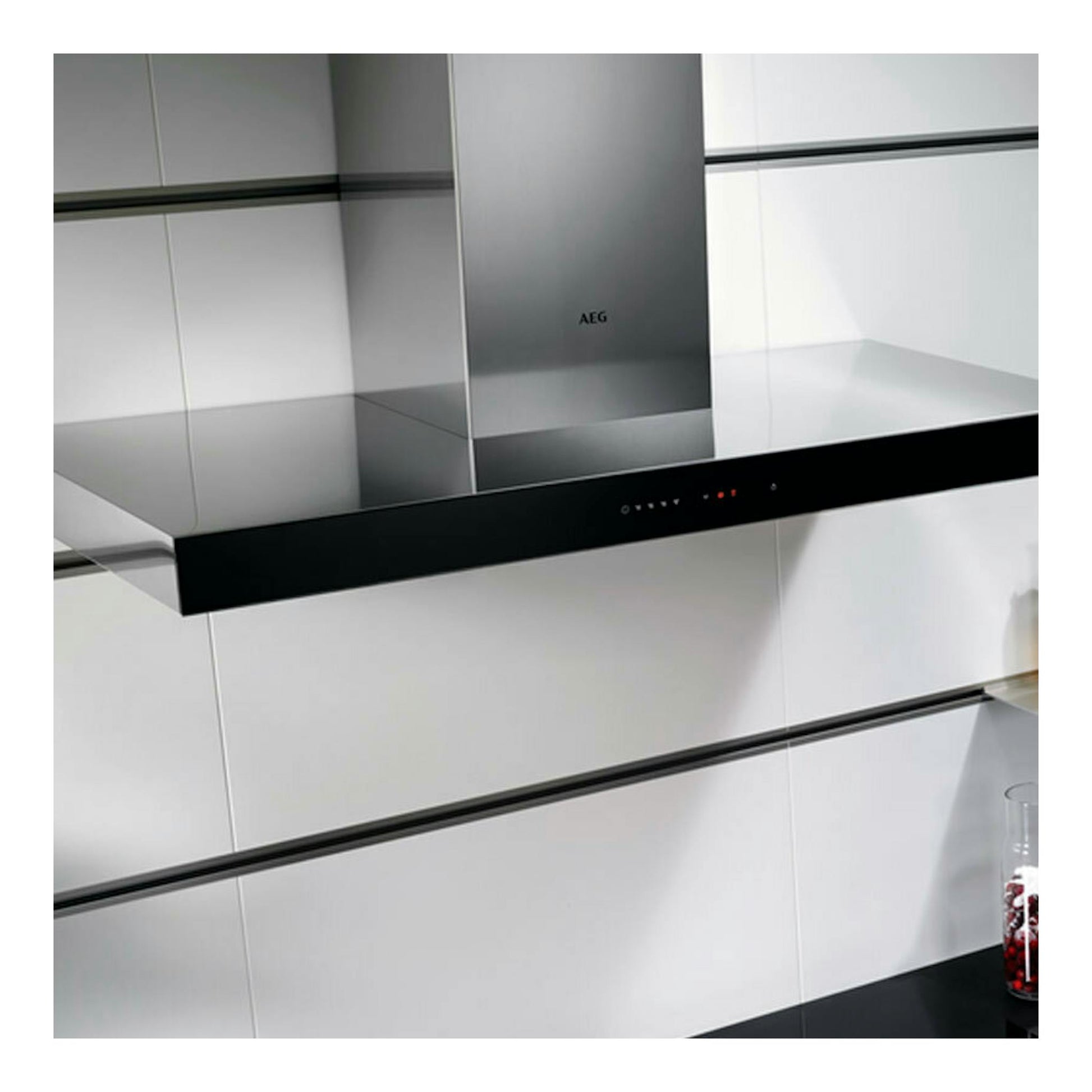Campana decorativa AEG DBE5960HB en inox, vista frontal en cocina moderna, con panel negro y chimenea central.